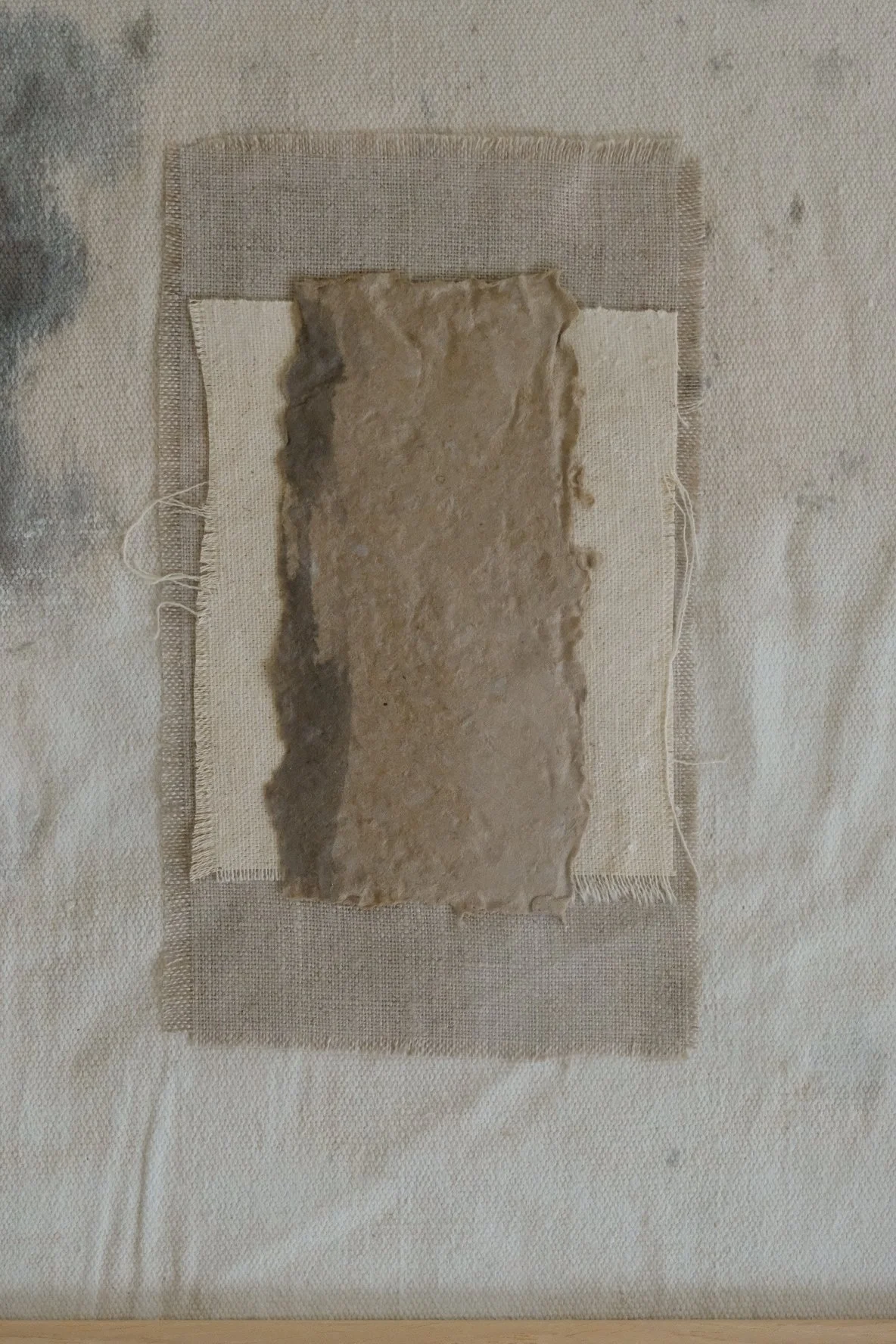Framed 11 x 14 collage of textured brown paper layered over ivory canvas and grey linen