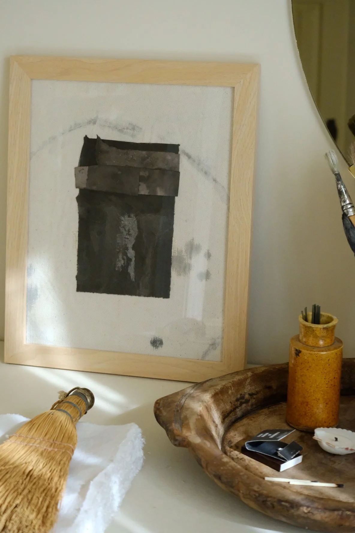 Framed 11 x 14 collage of layered near-black torn paper on pale canvas with grey rings