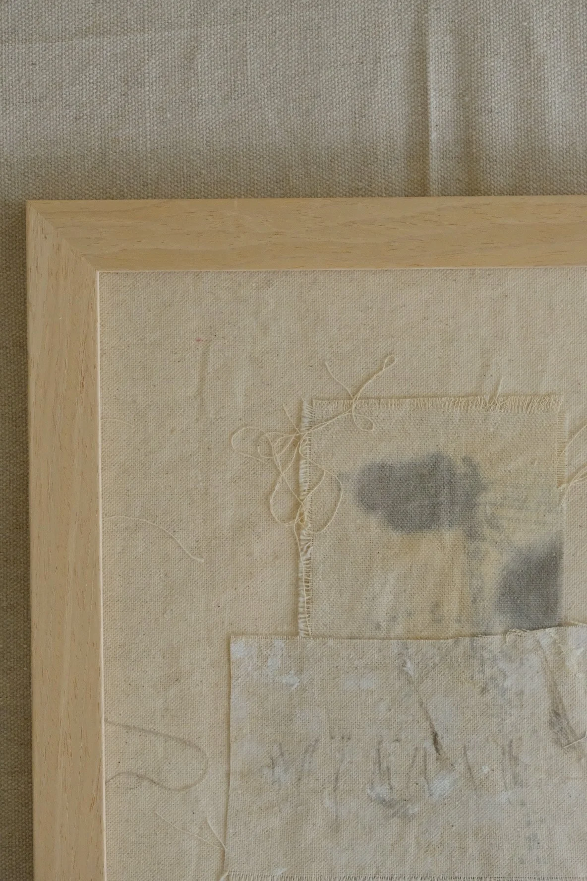 Framed 11 x 14 collage of layered canvas panels and a grey cloth patch with soft grey marks