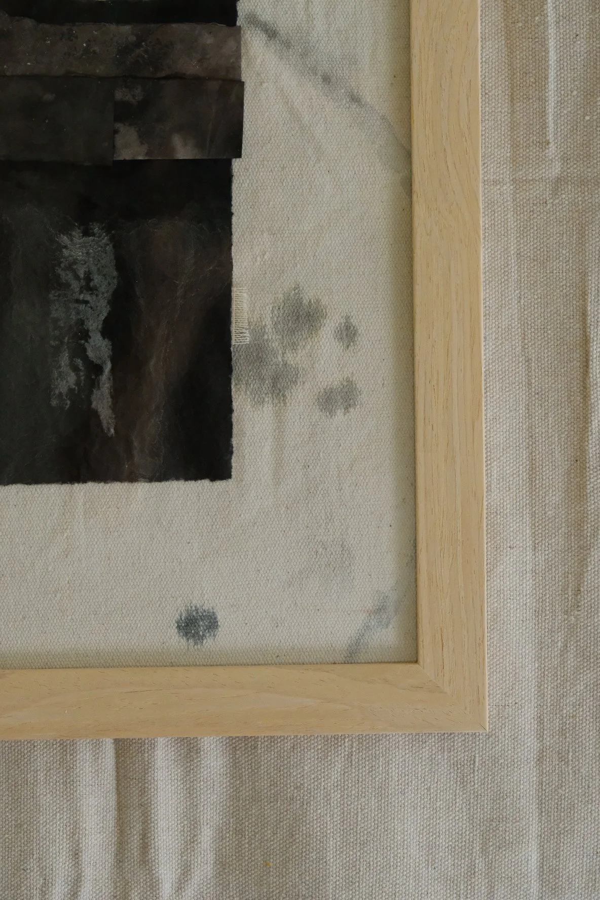 Framed 11 x 14 collage of layered near-black torn paper on pale canvas with grey rings
