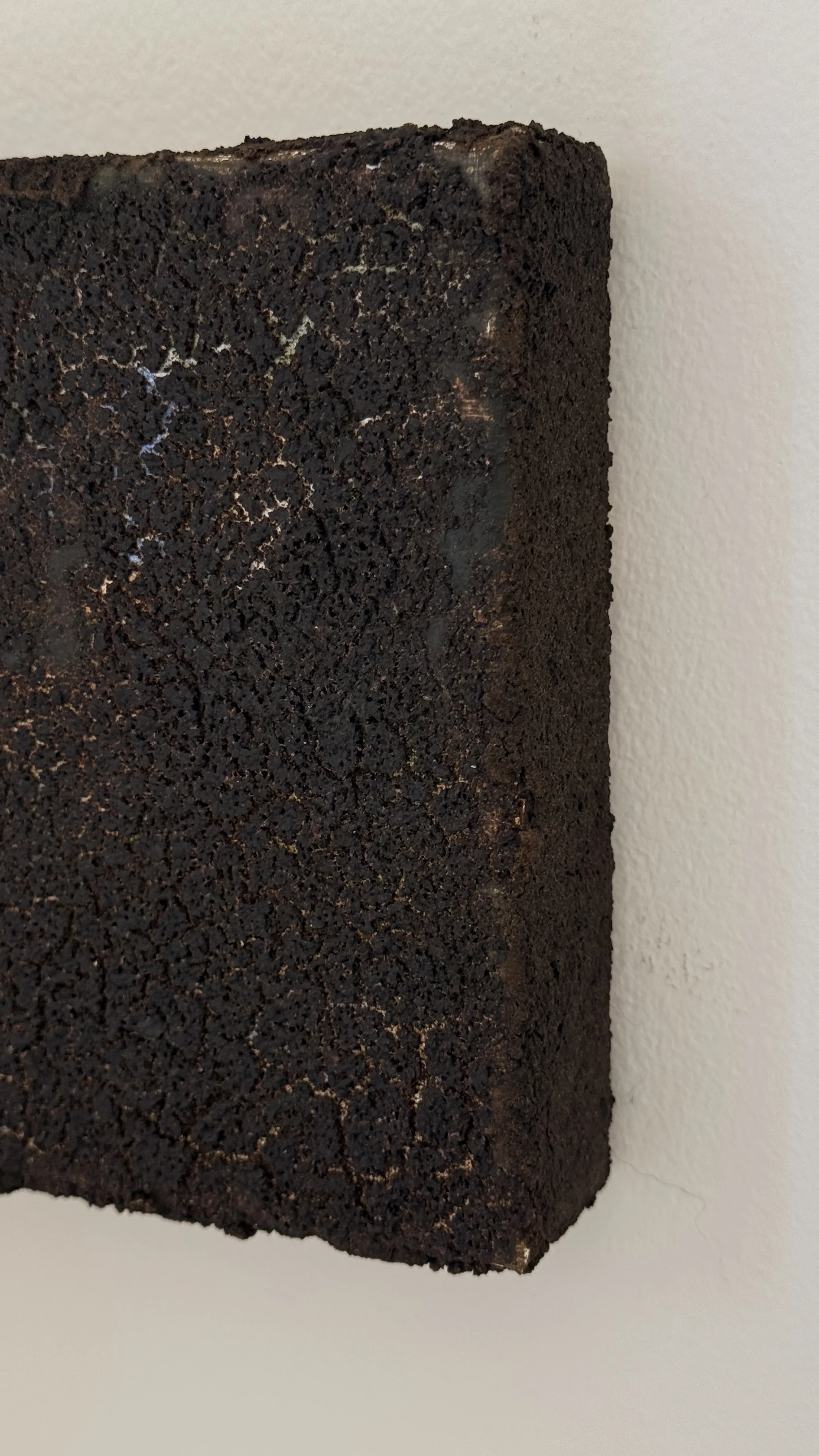 Small abstract artwork with a dense, cracked dark brown and black textured surface and faint pale veining, unframed 6x6 on linen