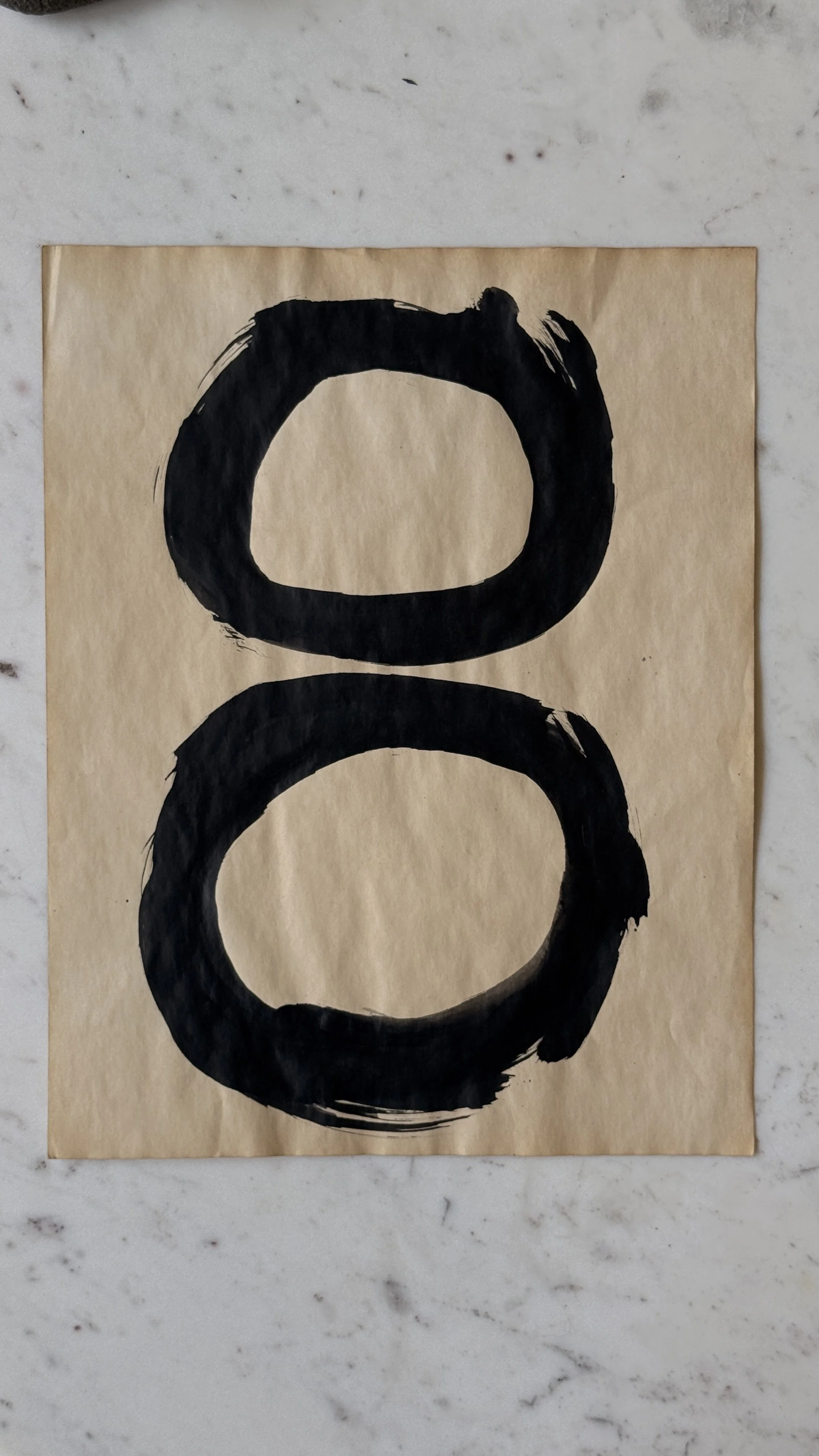 Original abstract ink artwork featuring hand-painted black circles stacked vertically on warm vintage paper.