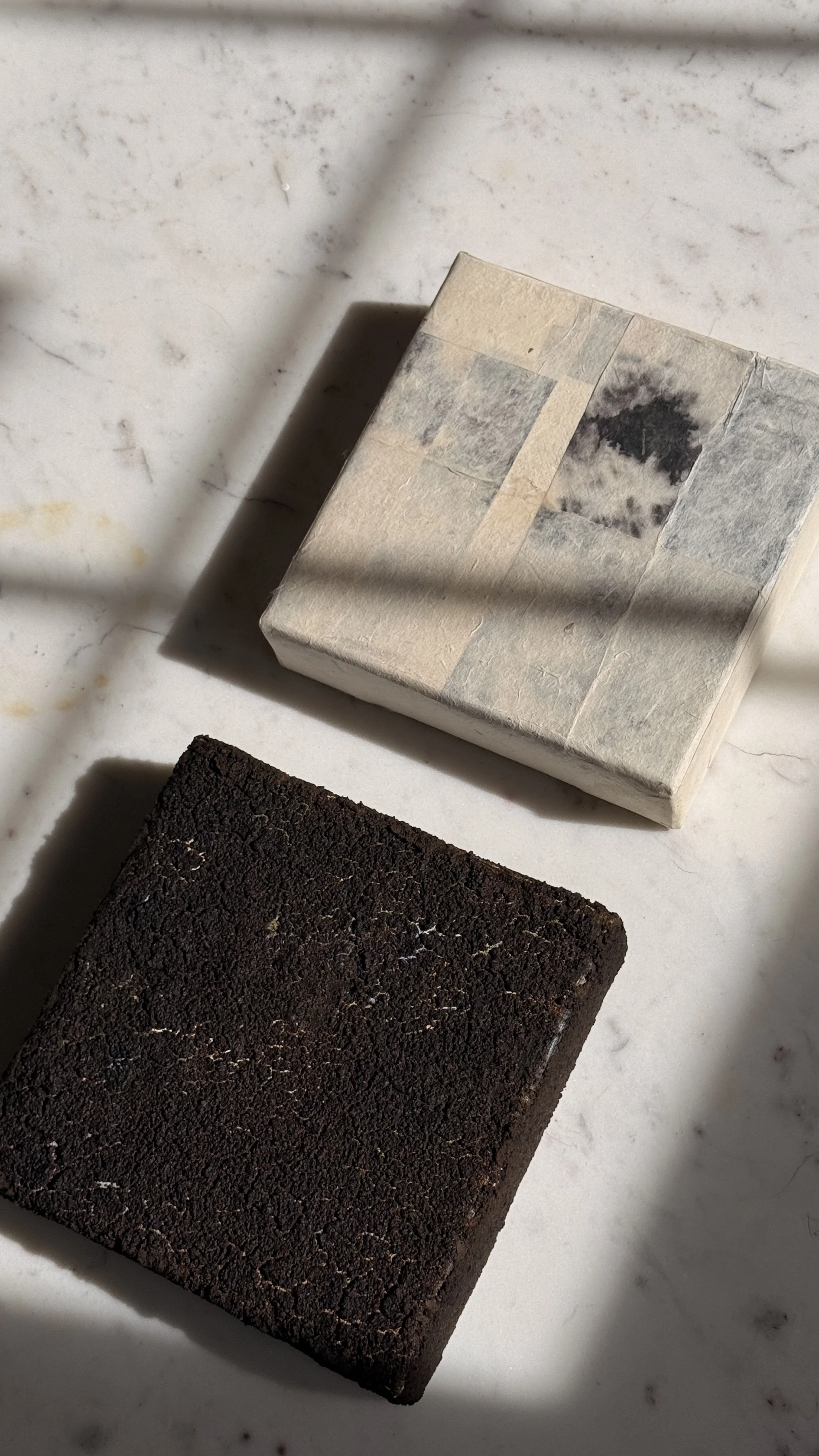 Small abstract collage of layered cream and grey handmade papers with a dark bloom-like mark near the top, unframed 6x6 art