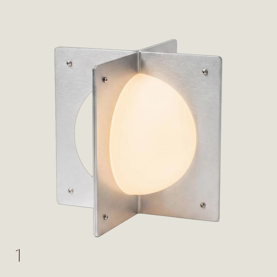 Sculptural P01 Mini table lamp with brushed aluminum cross panels and a glowing frosted glass globe