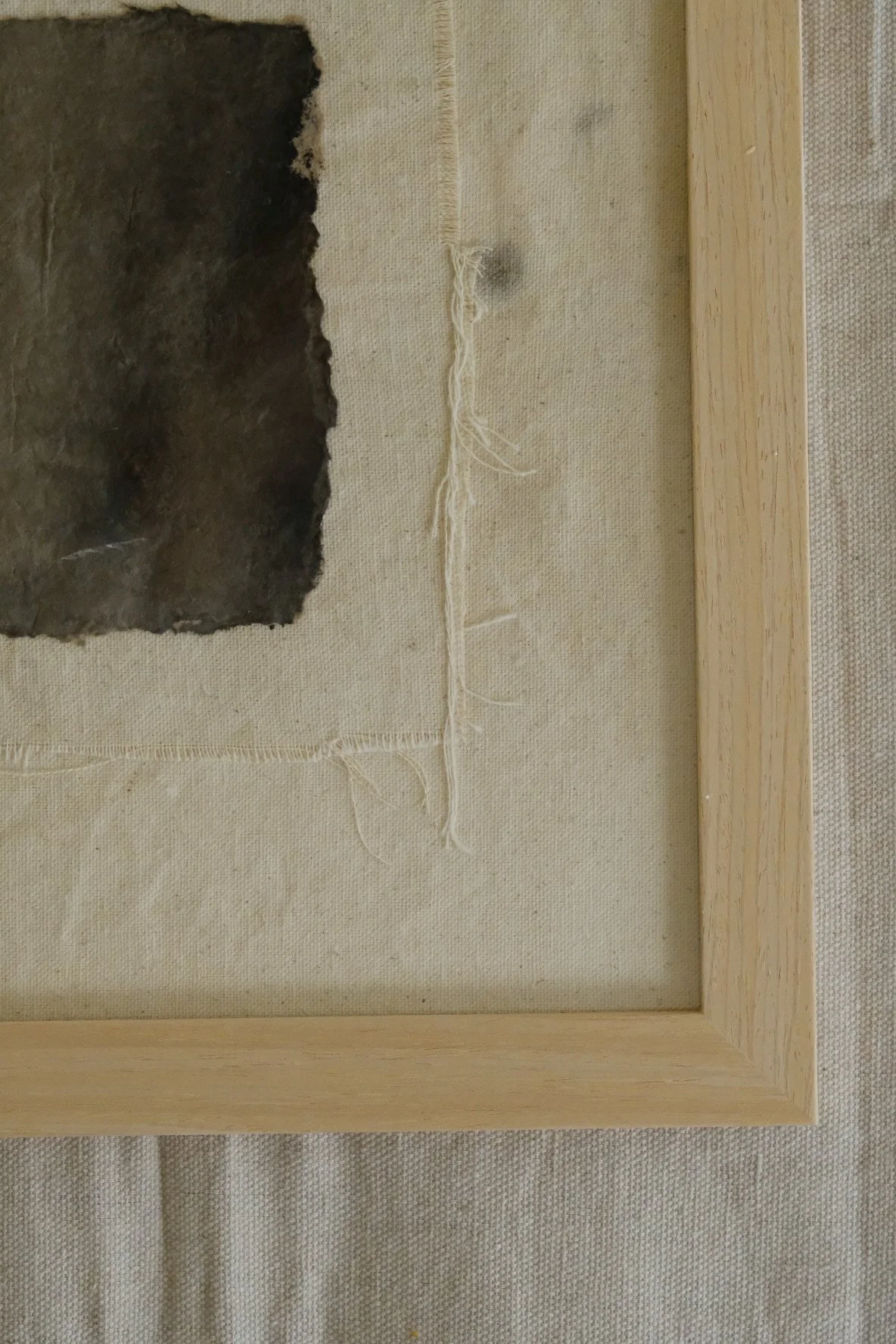 Framed 11 x 14 collage of torn dark paper on a stitched raw canvas panel