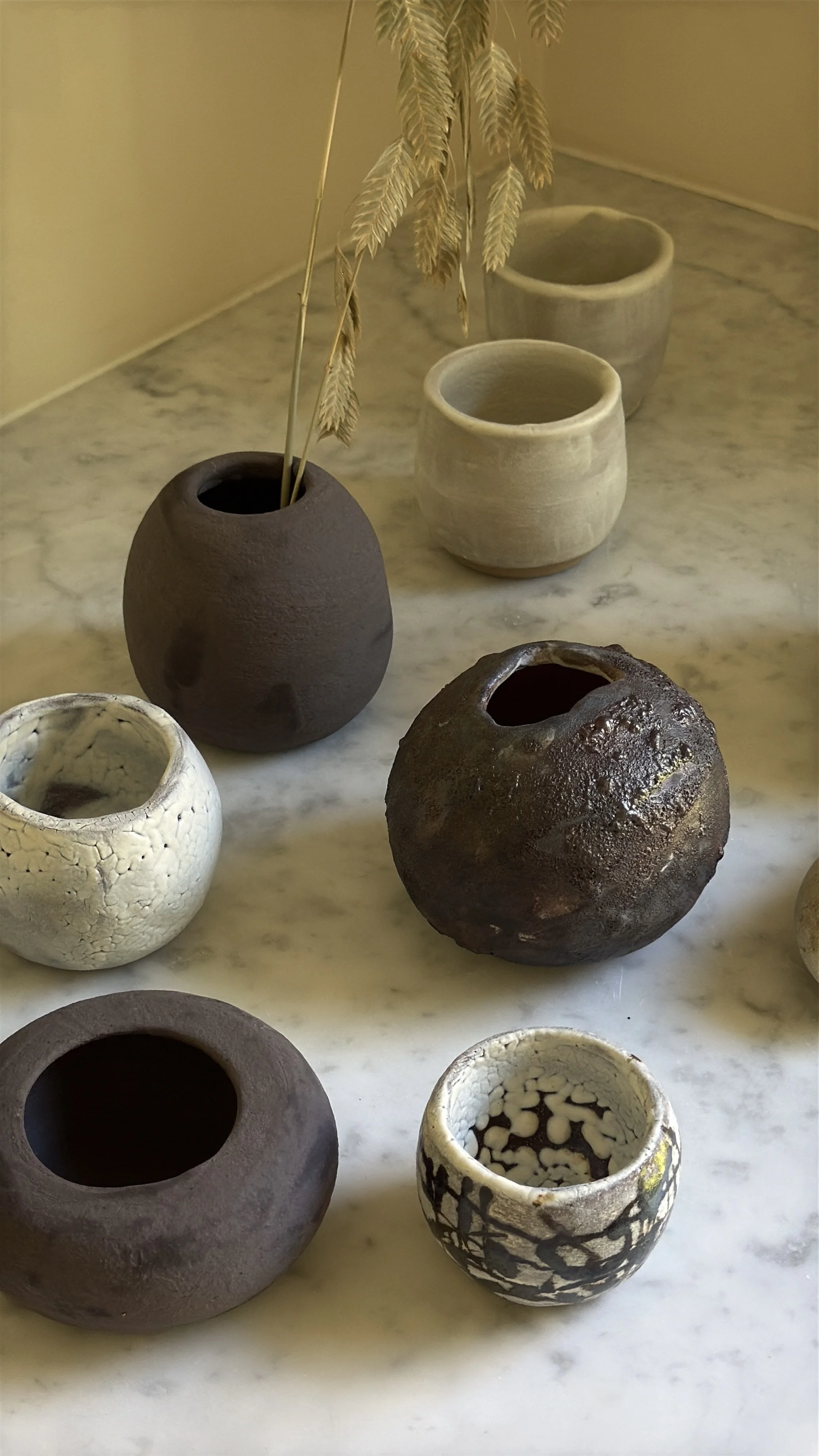 Round ceramic cup with white crackle glaze, black splatter and grid-like brush marks, and a small gold accent, pale crackled interior