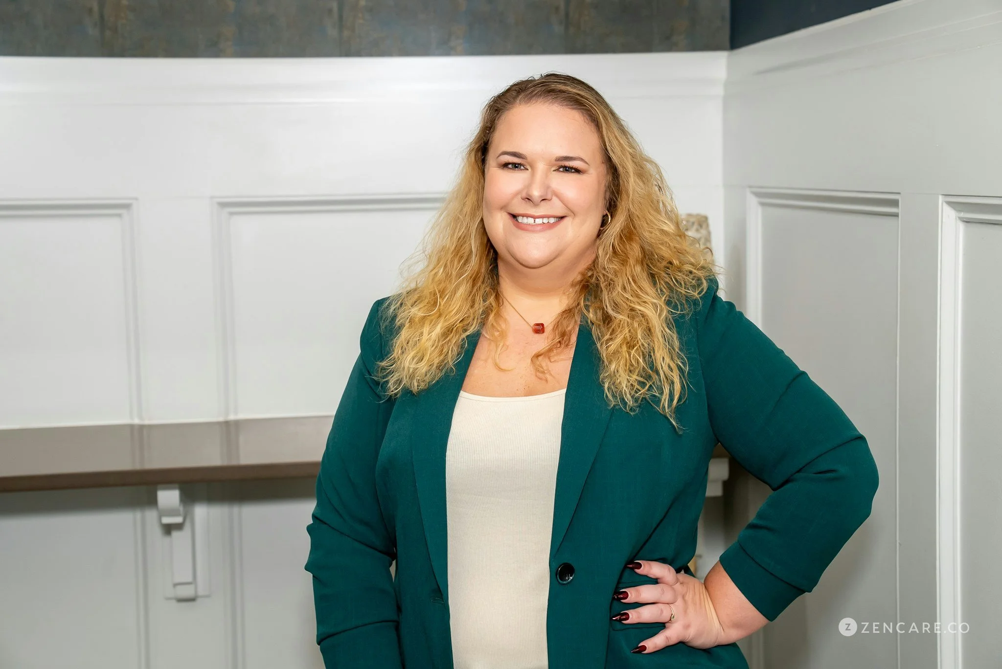 woman poses smiling in green blazer