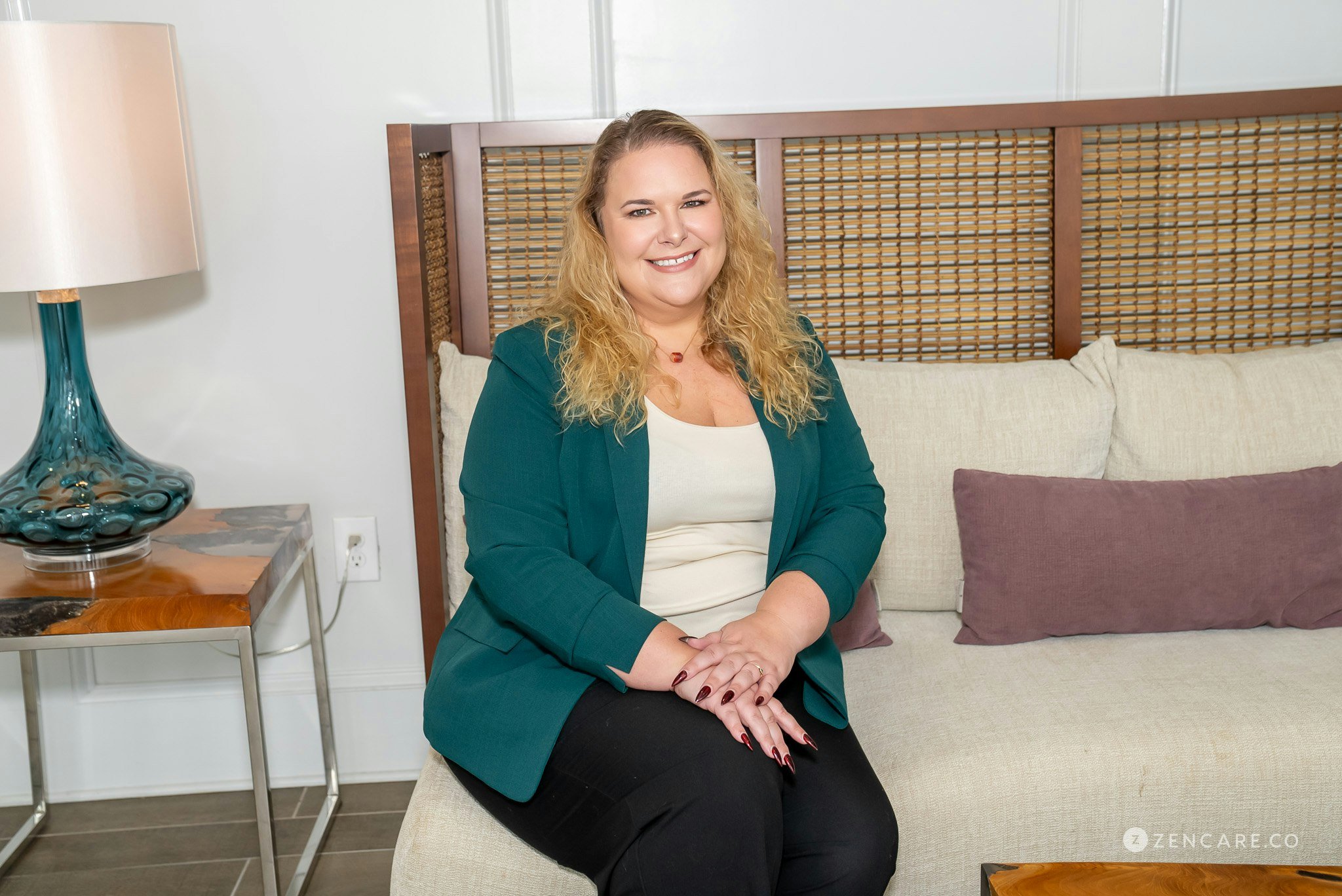 woman sitting on couch and smiling at camera.