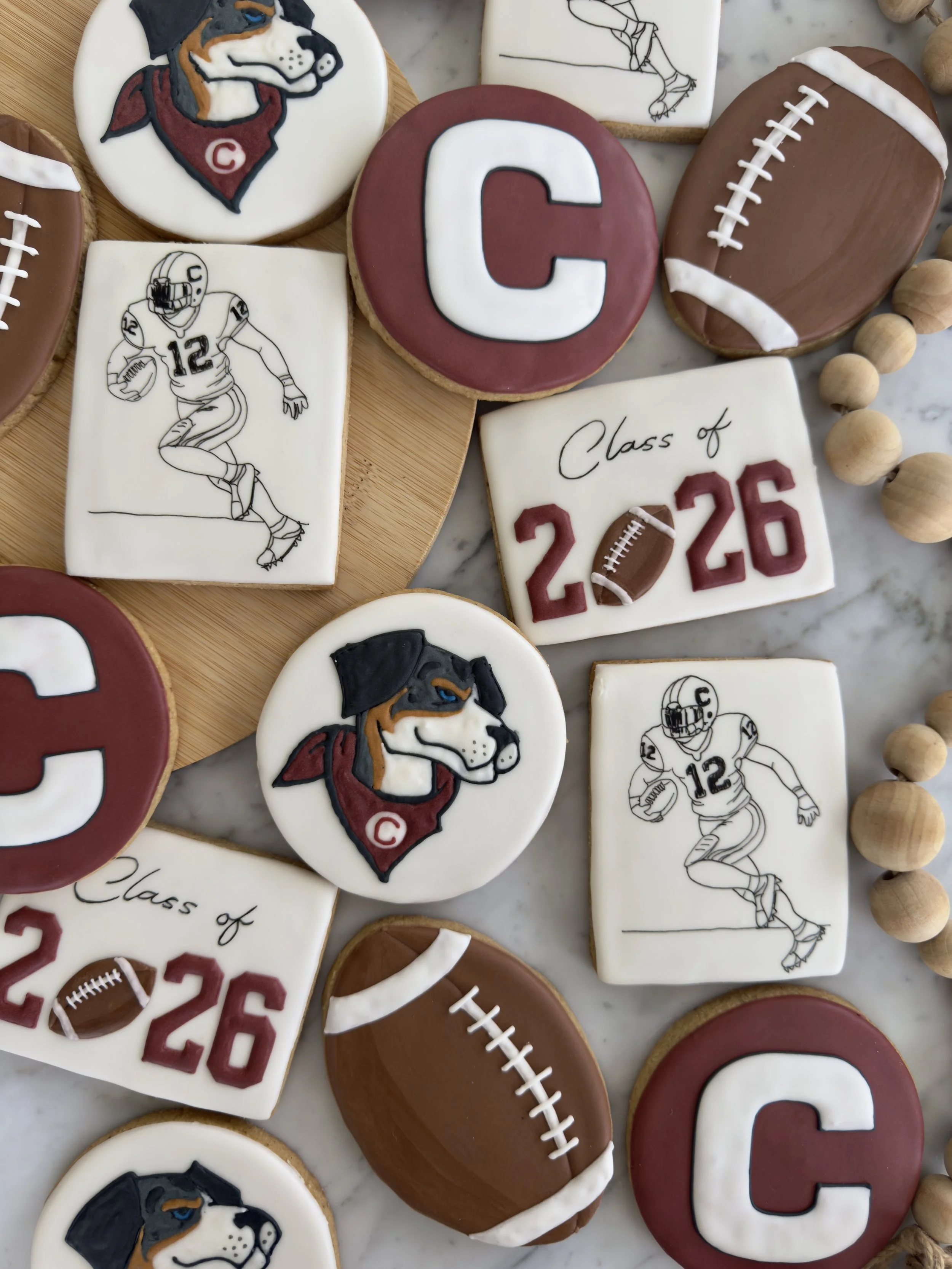 Cookies decorated with football and Cleveland Browns themes, featuring a dog's face, football icons, and graduation messages for Class of 2026.