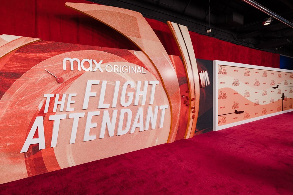 Red carpet event backdrop for Max Original's 'The Flight Attendant' with logo and graphics.