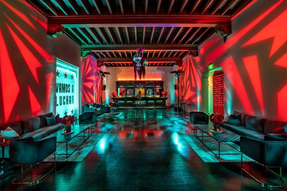 Colorful venue interior with dramatic lighting, couches, and tables