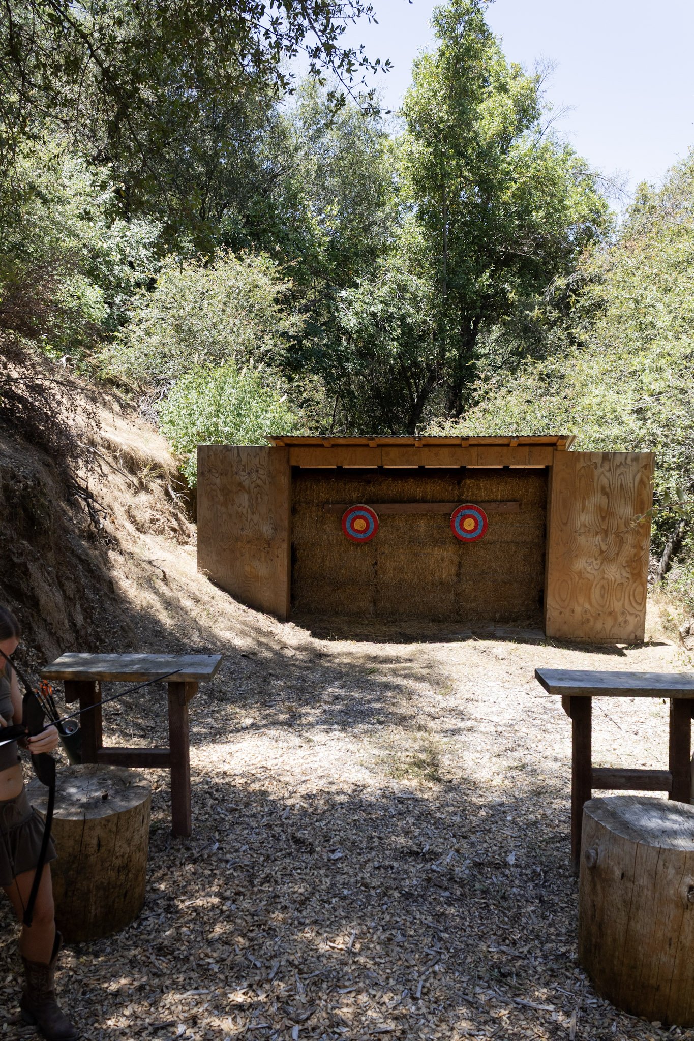 Outdoor archery range at Baxter Ranch surrounded by forest, featuring wooden target structures and a natural mountain setting for guests to enjoy outdoor activities.