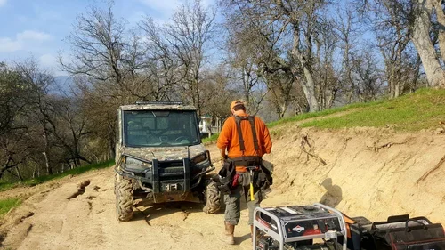 Baxter Ranch team member working on the driveway leading to Hilltop House, creating access through the wooded landscape as part of the property’s development.