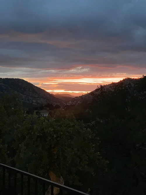 Golden hour from the Hilltop House patio at Baxter Ranch, featuring sweeping valley views, mountain silhouettes, and peaceful evenings surrounded by nature.