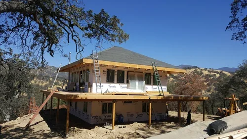 The early construction of Hilltop House at Baxter Ranch, built into the hillside among the trees with sweeping views of the surrounding Sierra Nevada foothills.