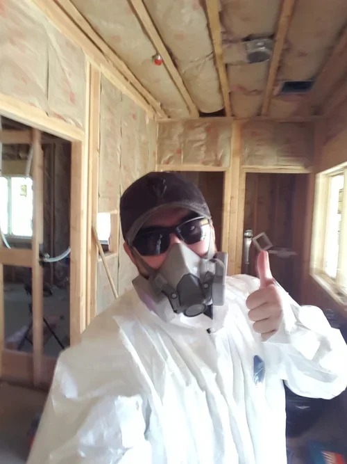 A member of the Baxter Ranch family helping build the property, working inside a construction site surrounded by exposed wood framing and the early stages of the mountain retreat.
