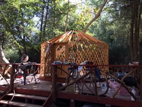 The Creekside Yurt at Baxter Ranch taking shape during construction, built among the forest and natural landscape as part of the creation of this mountain retreat.