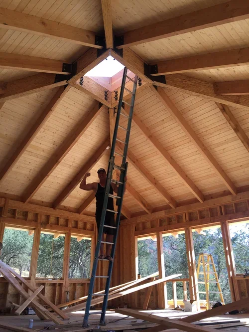 The interior of Hilltop House at Baxter Ranch taking shape as the owner installs wood paneling around the skylight and exposed beams, highlighting the handcrafted details of the mountain retreat.