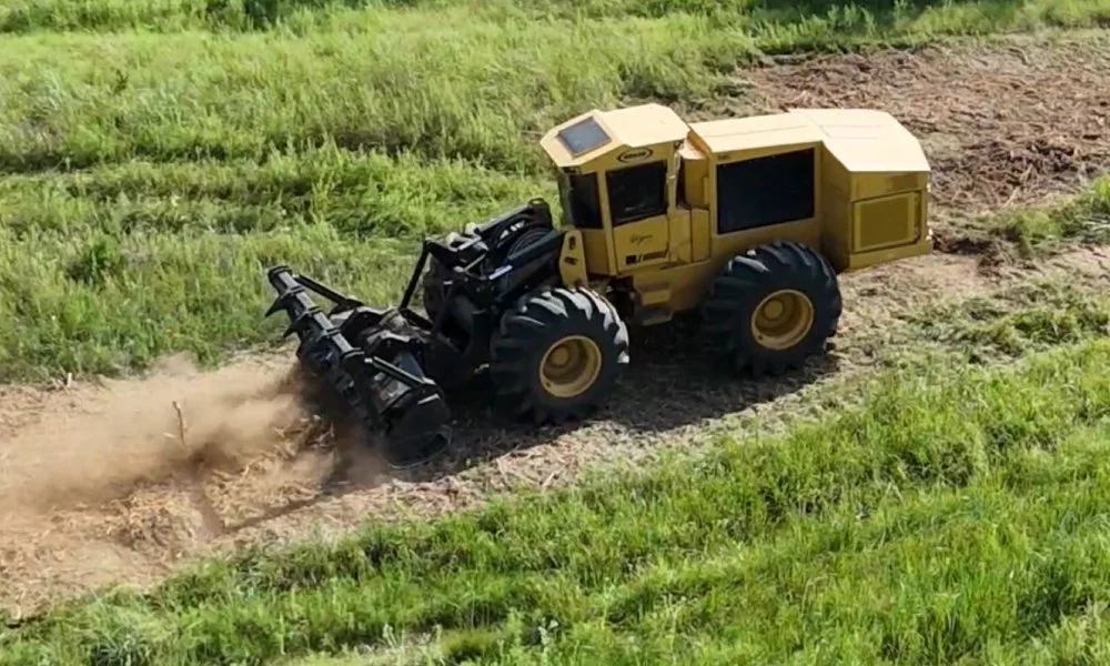 Large yellow land clearing machinery in operation