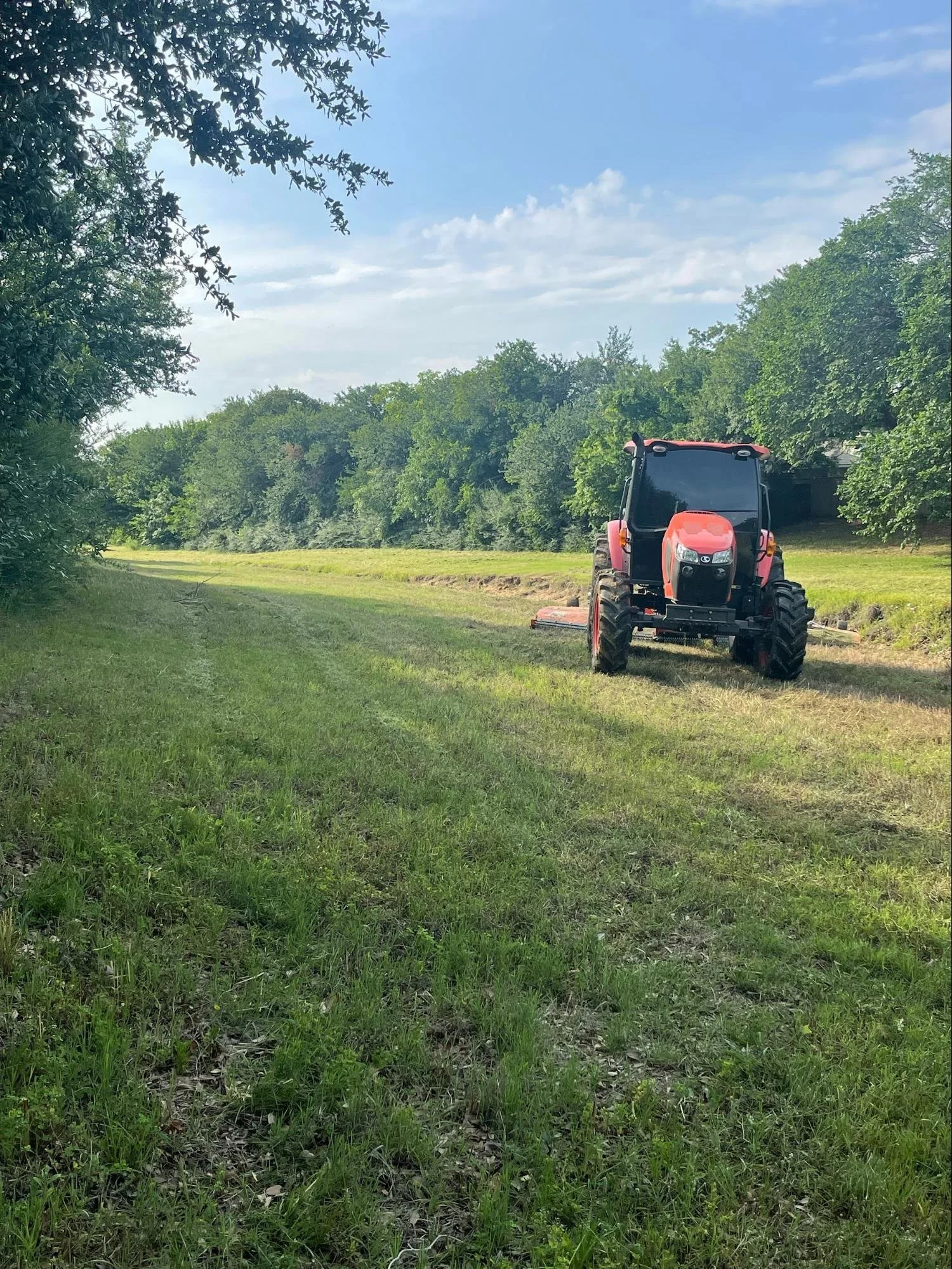 Tractor mower mowing grass in Bowie, TX.