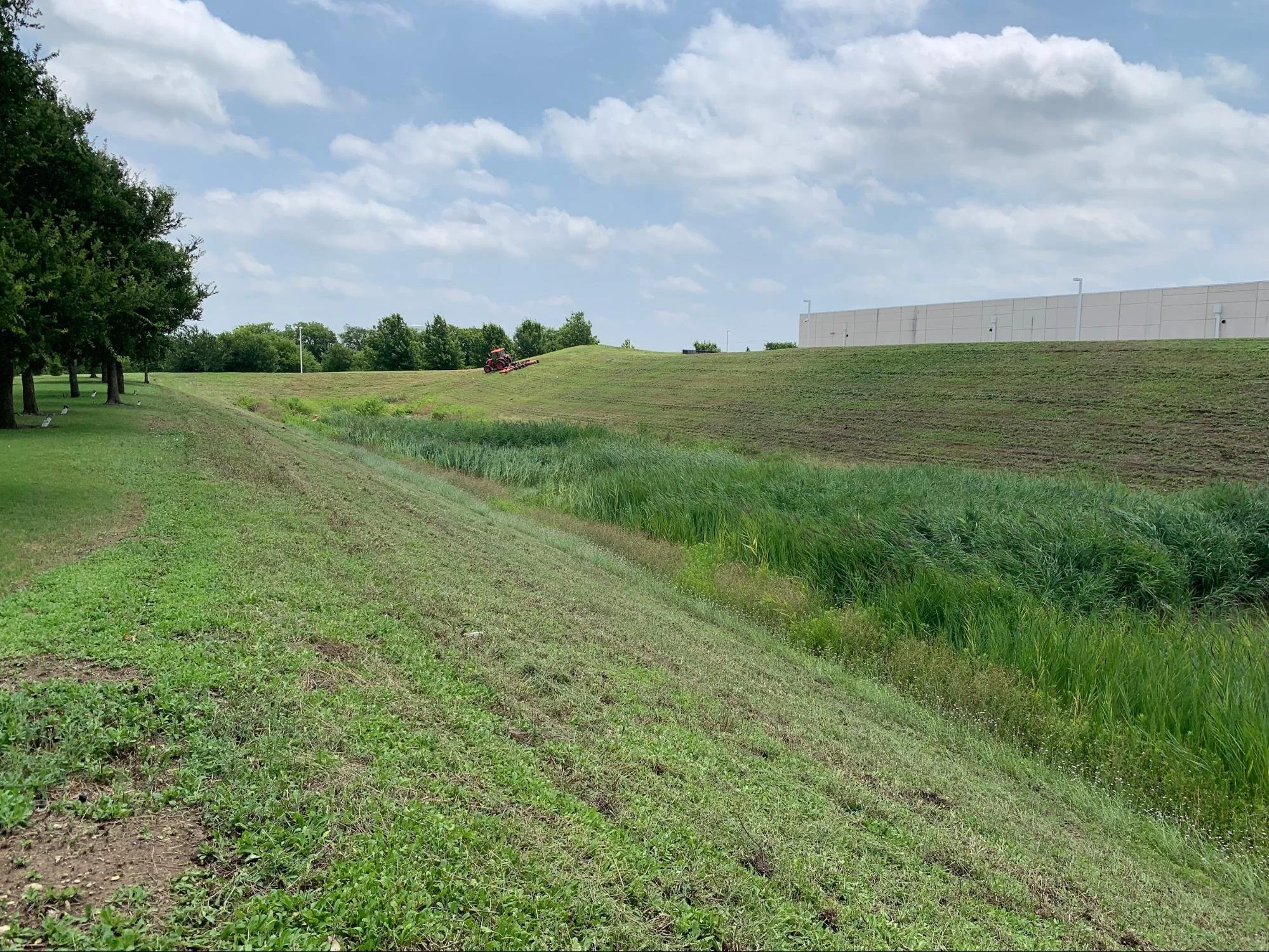 Green culvert with freshly mowed, green grass in Montague, TX.