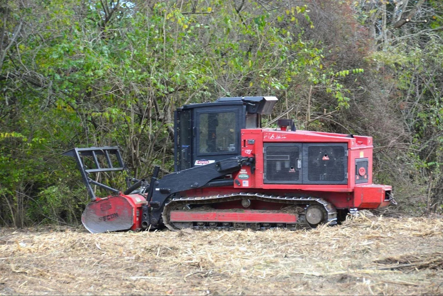 Red Tractor performing a forestry mulching job
