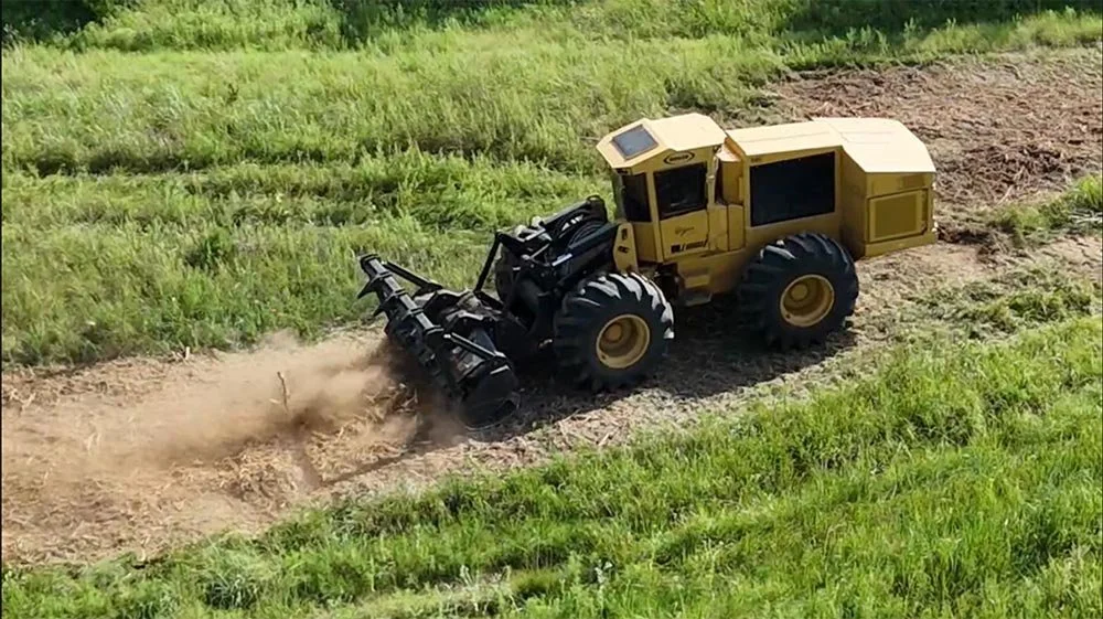 An overhead view of land-clearing equipment surrounded by green pasture