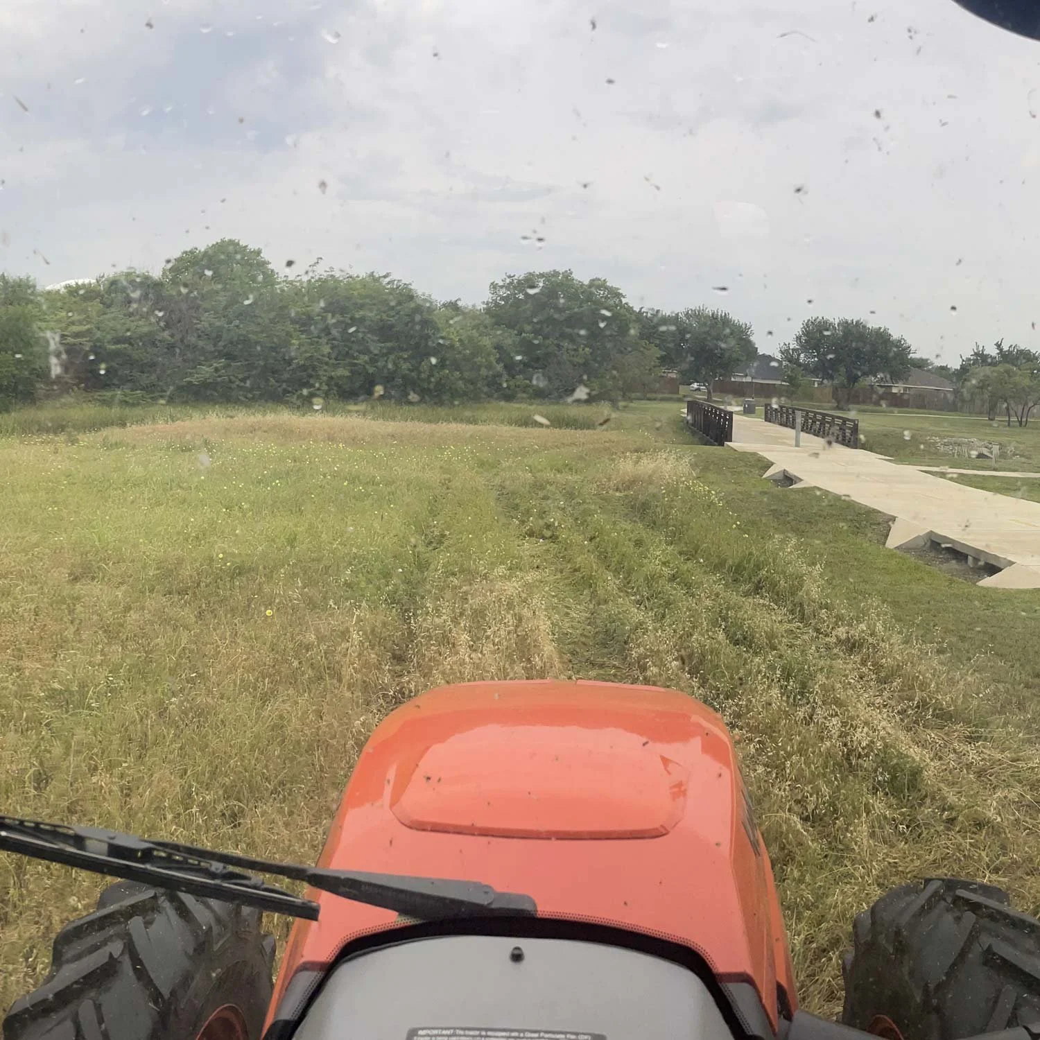 A view of open land through a tractor’s windshield