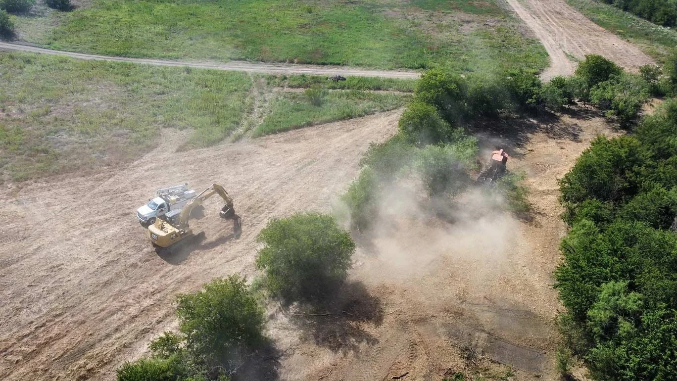 An overhead view of vehicles and equipment working land
