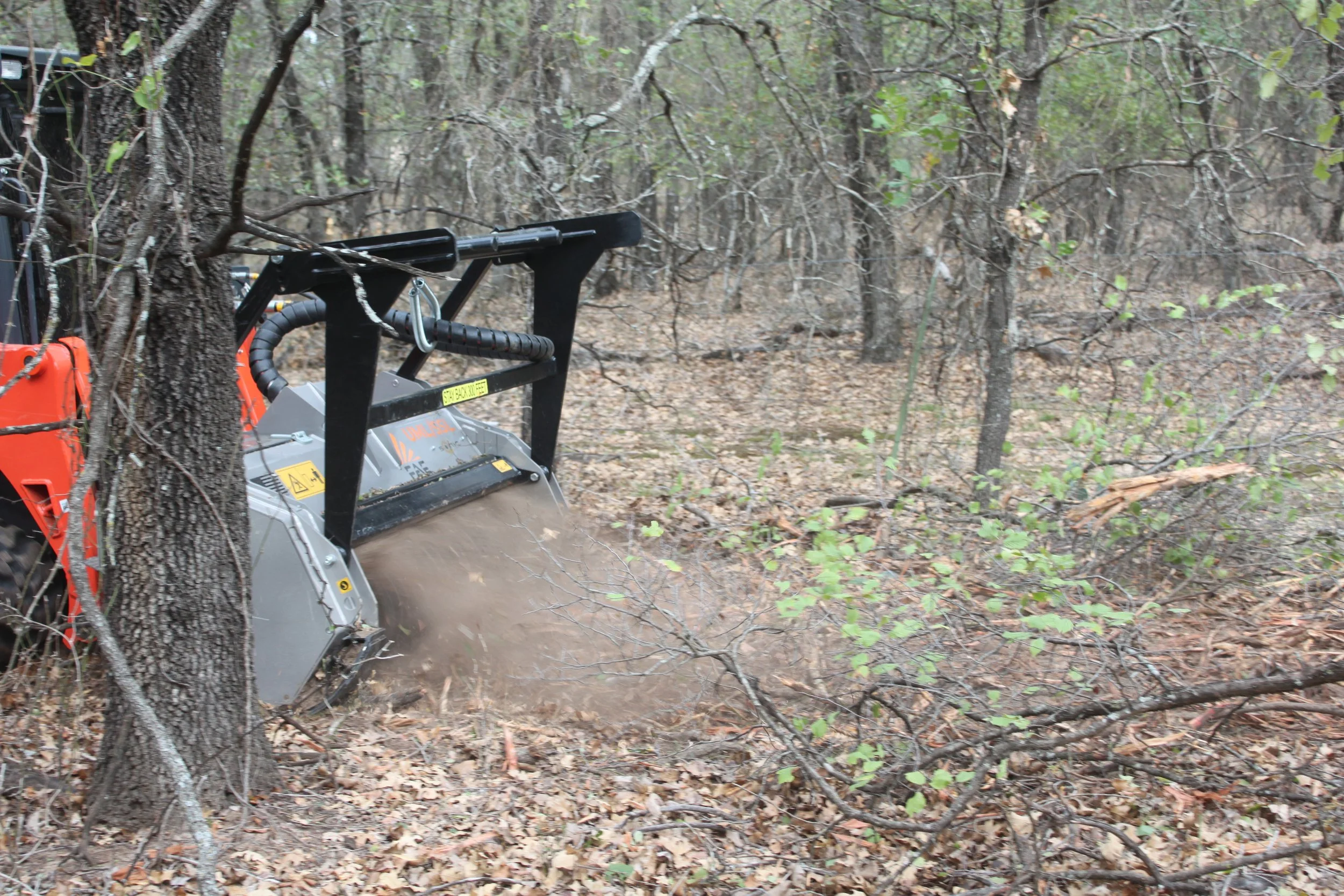 Skid-steer mowing around trees