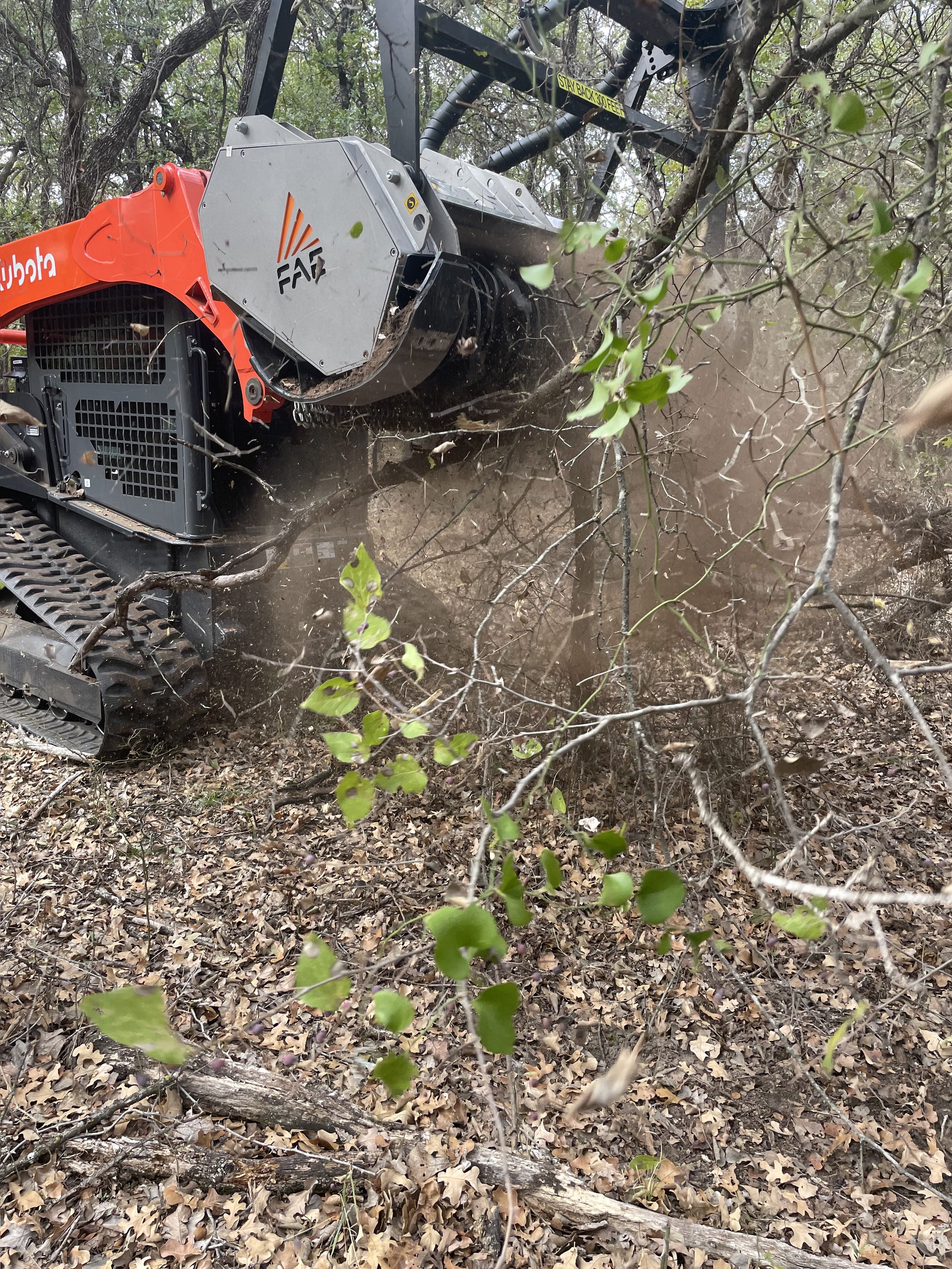 Skid-steer mowing around trees