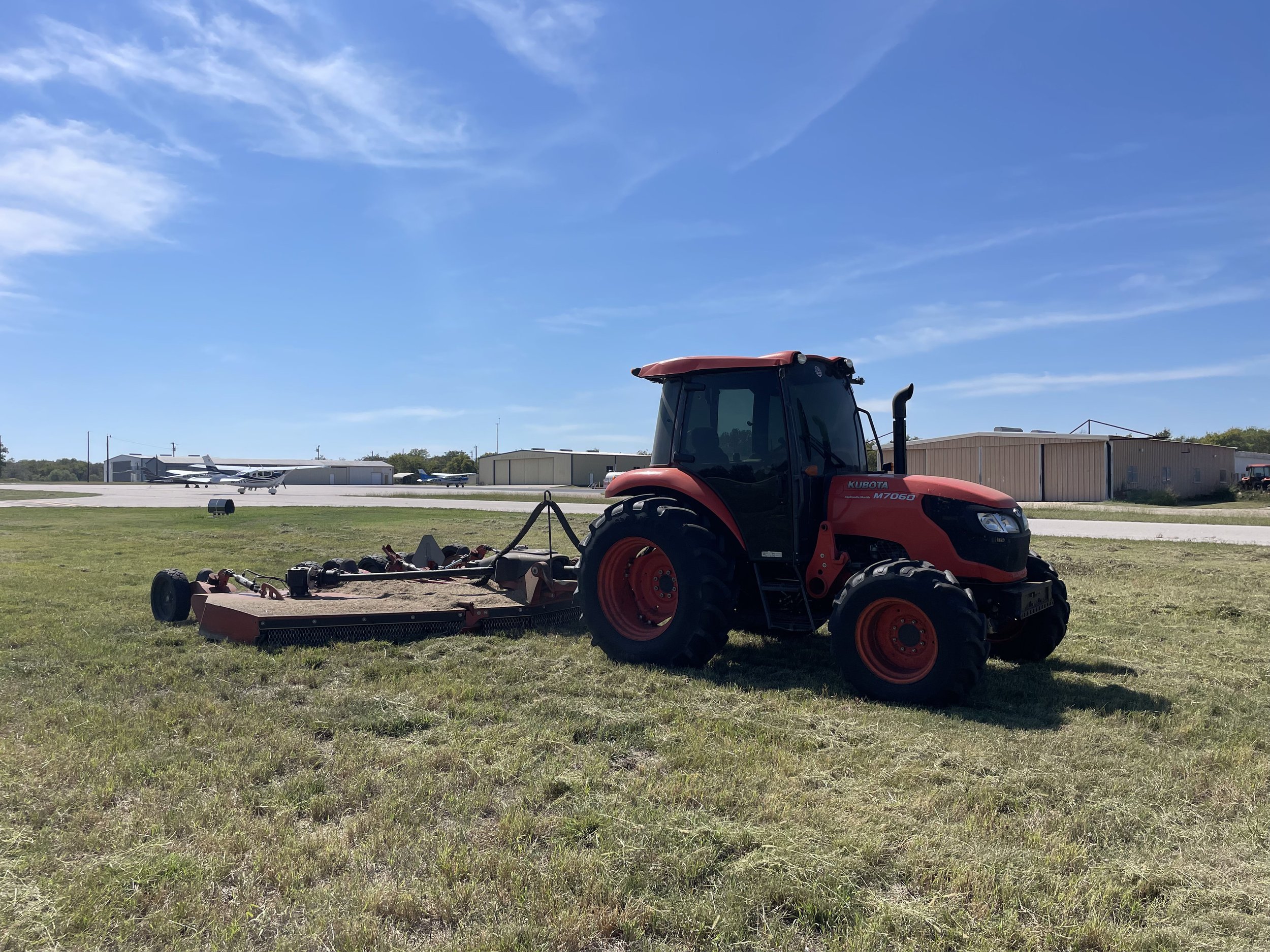 Red tractor mowing a field