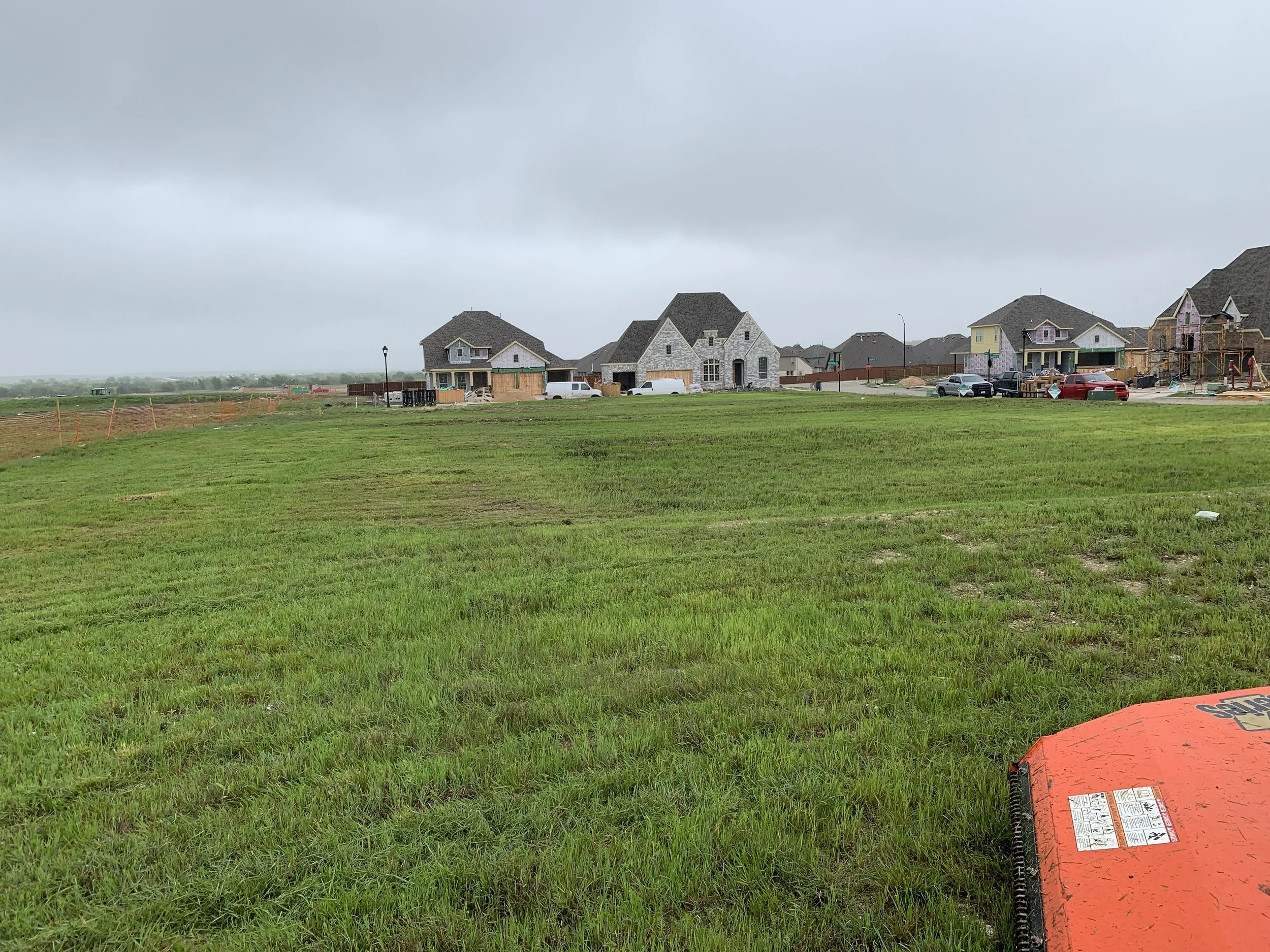 red tractor mowing through green field