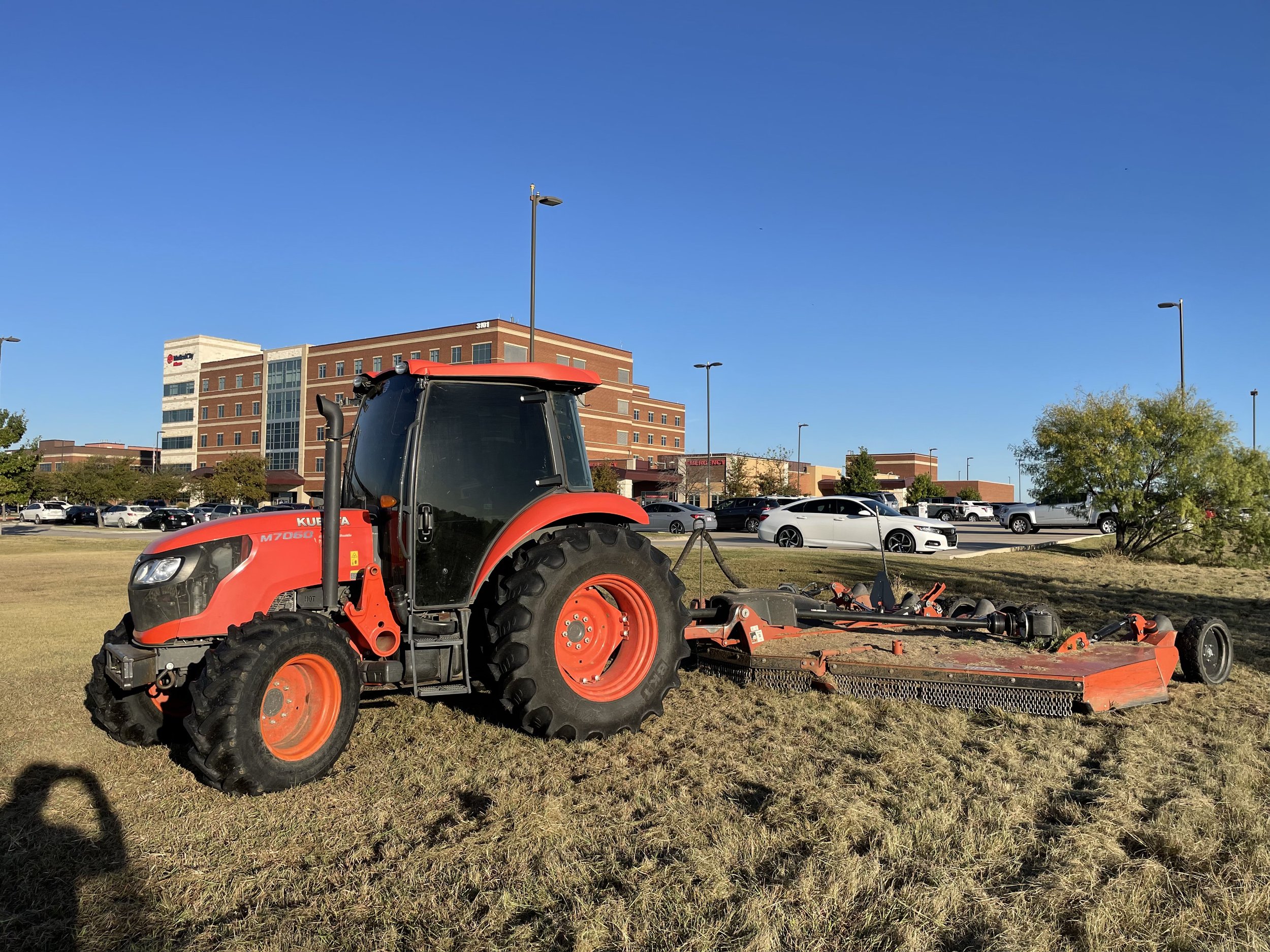 Red tractor mowing a field