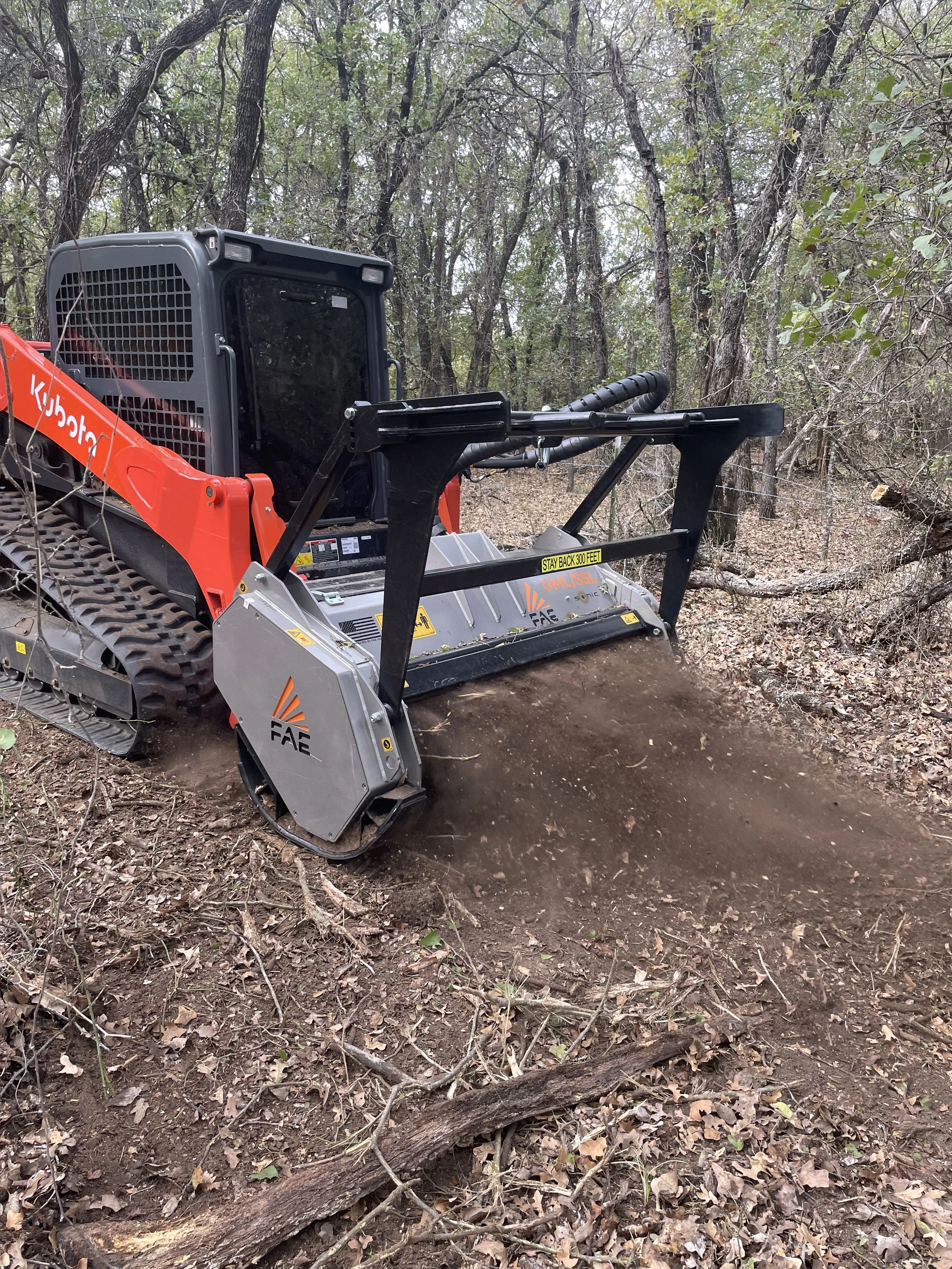 Skid-steer mowing around trees
