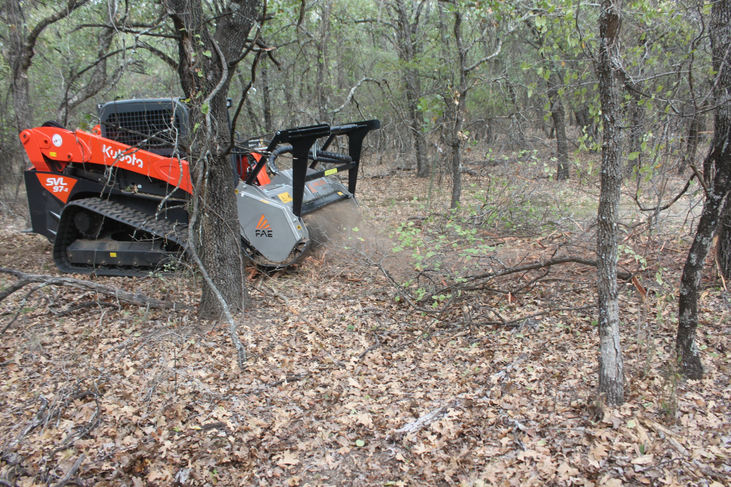 Skid-steer mowing around trees