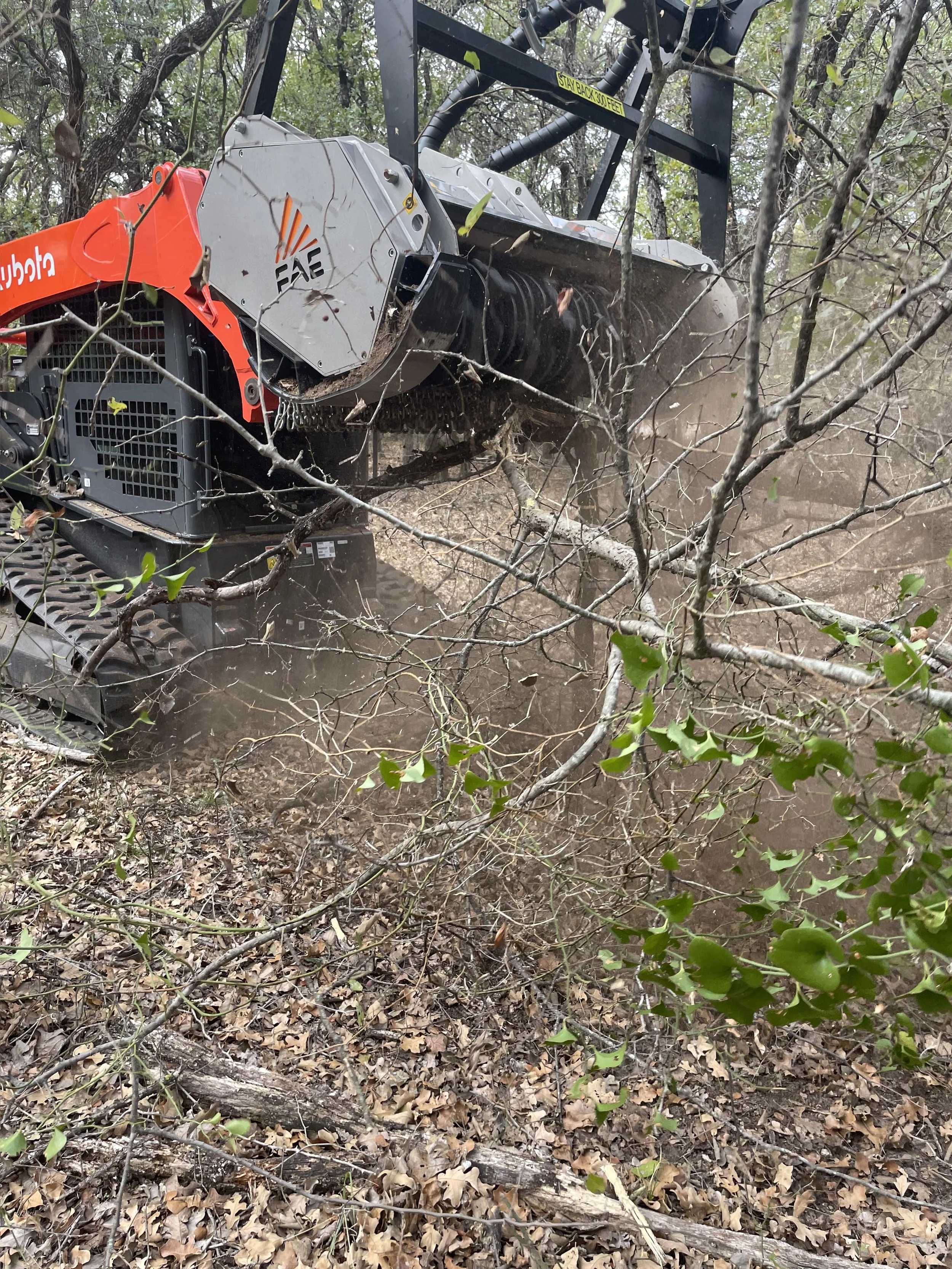 Skid-steer mowing around trees