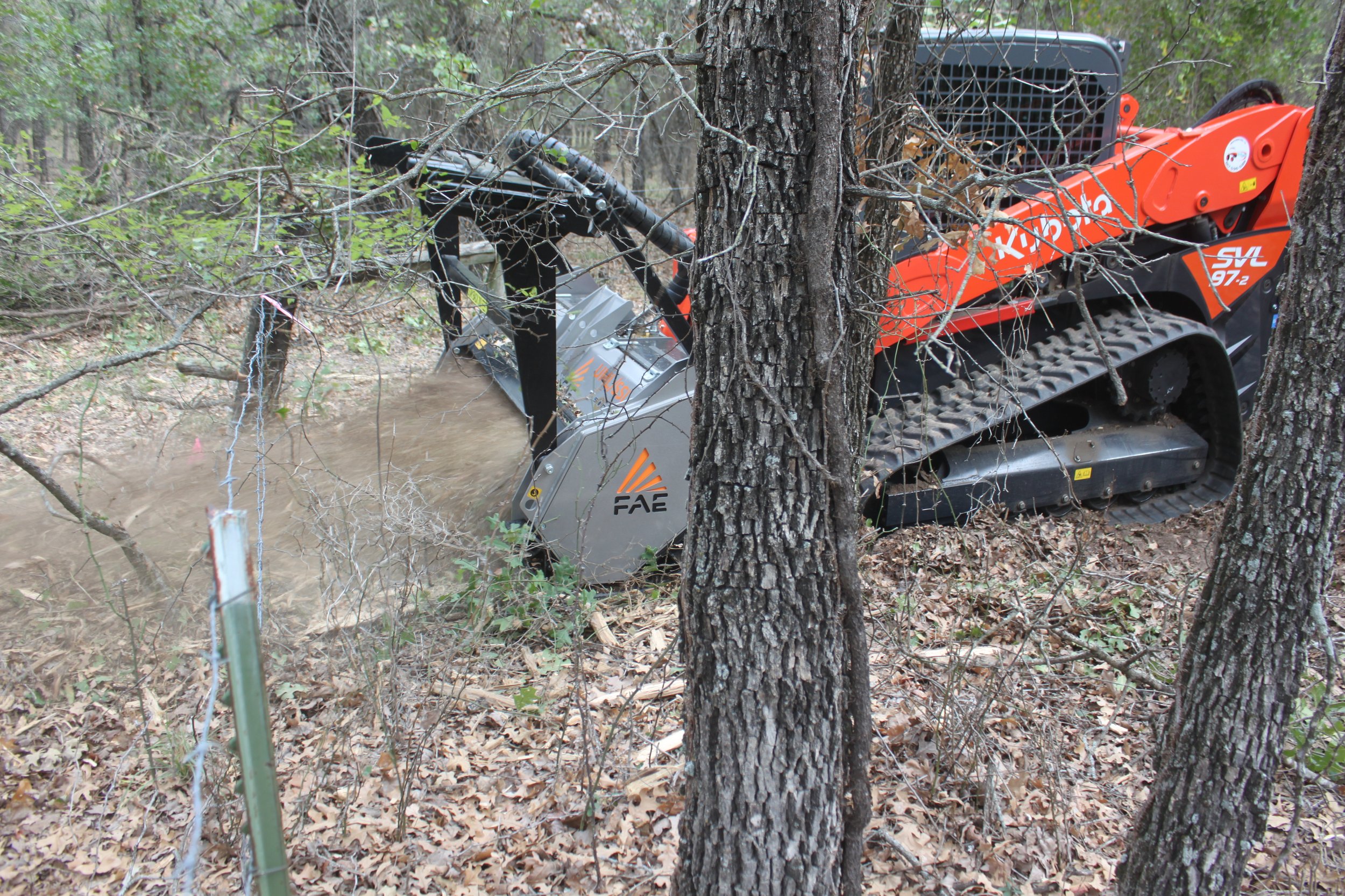 Skid-steer mowing through forest