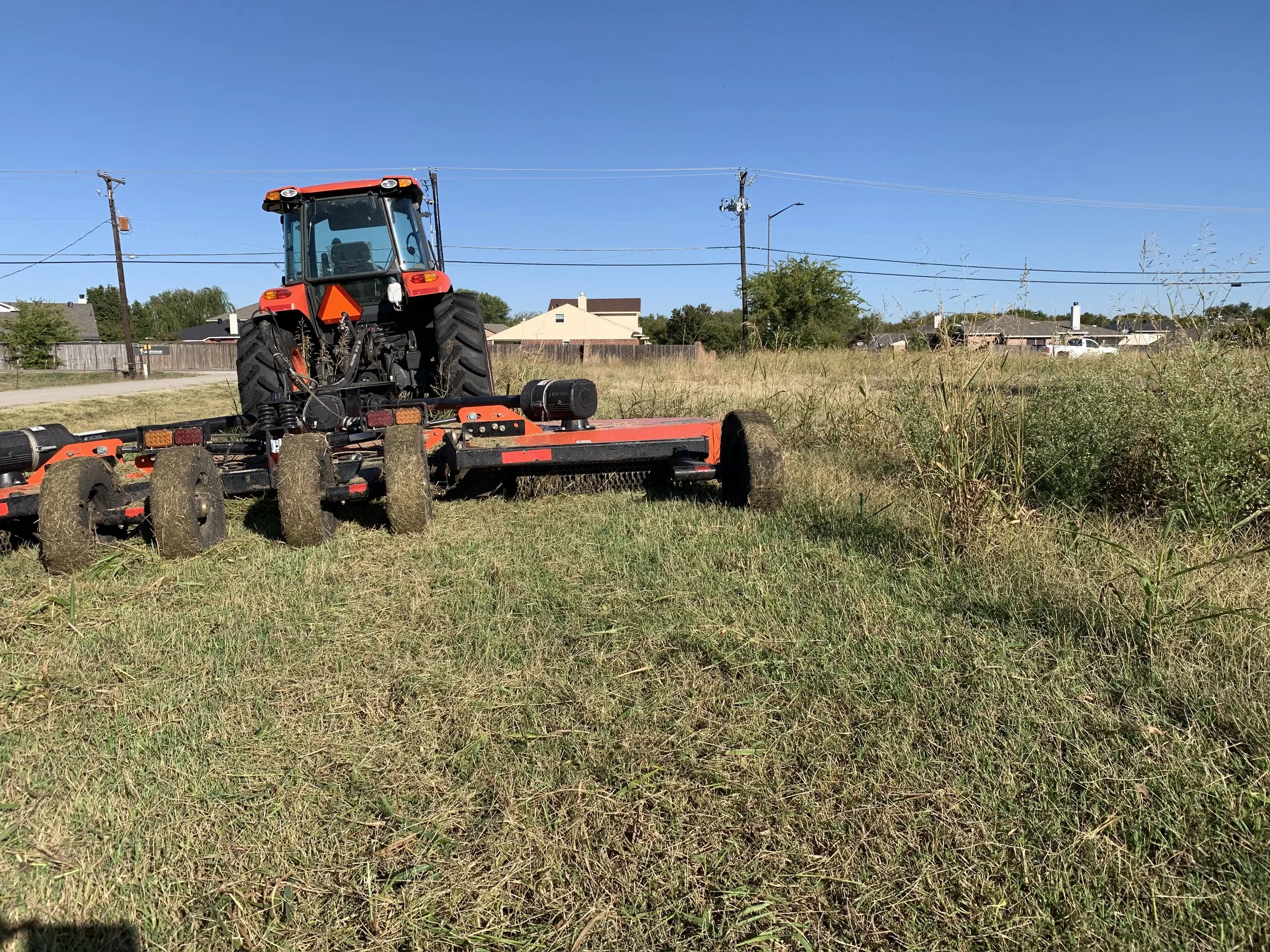 Tractor mowing a tall-grass field