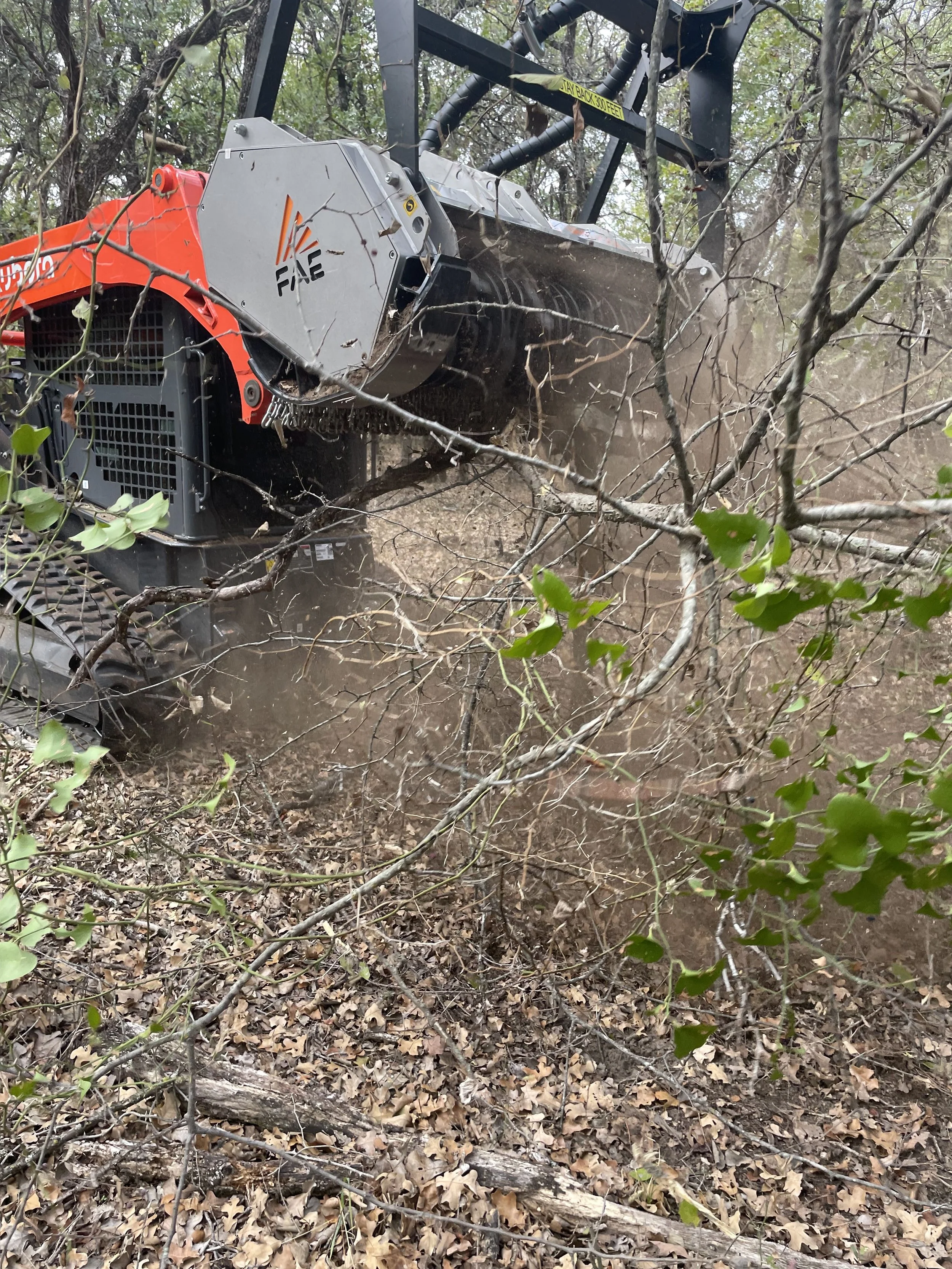 Skid-steer mowing around trees