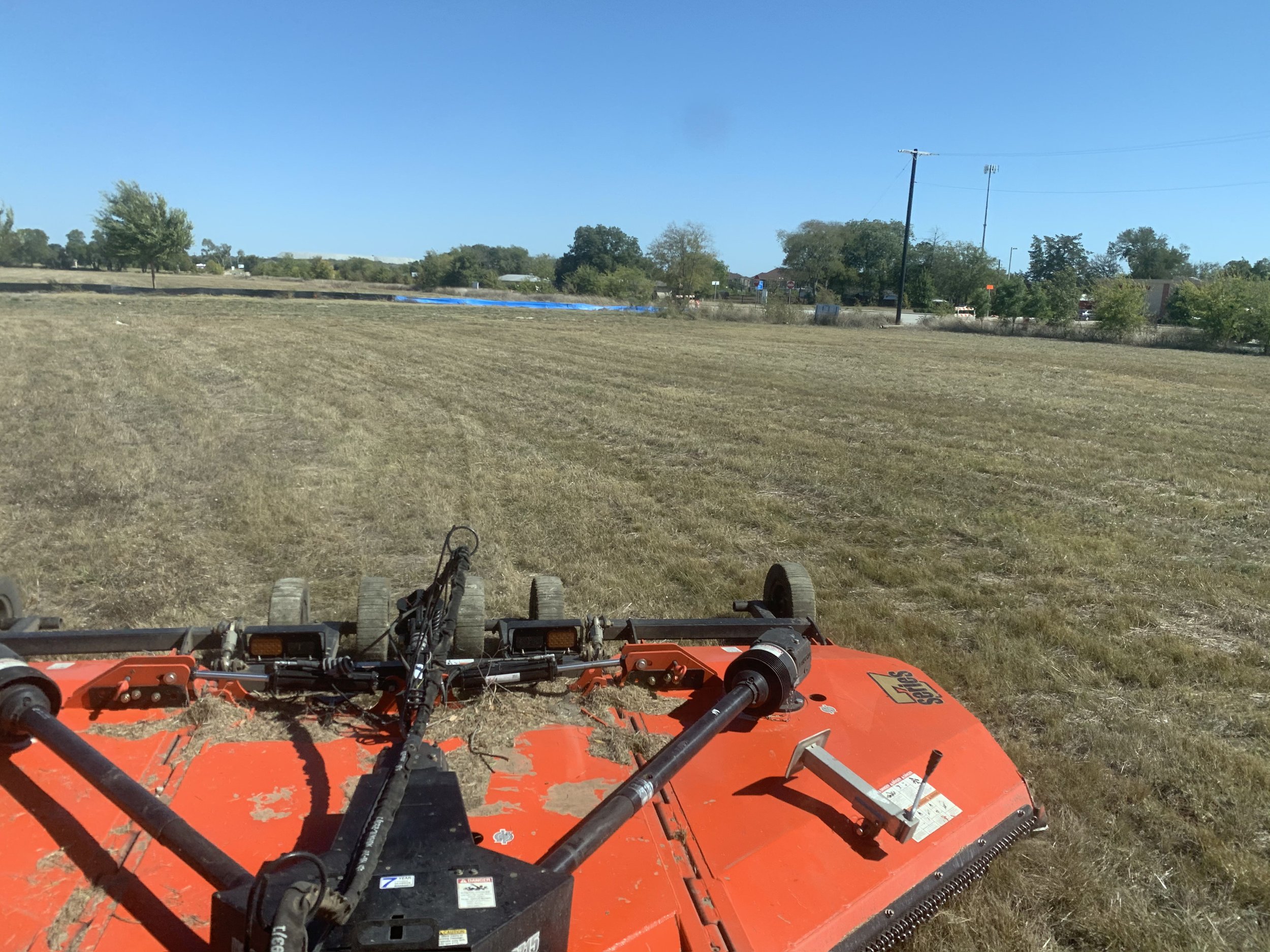 Tractor mowing through field