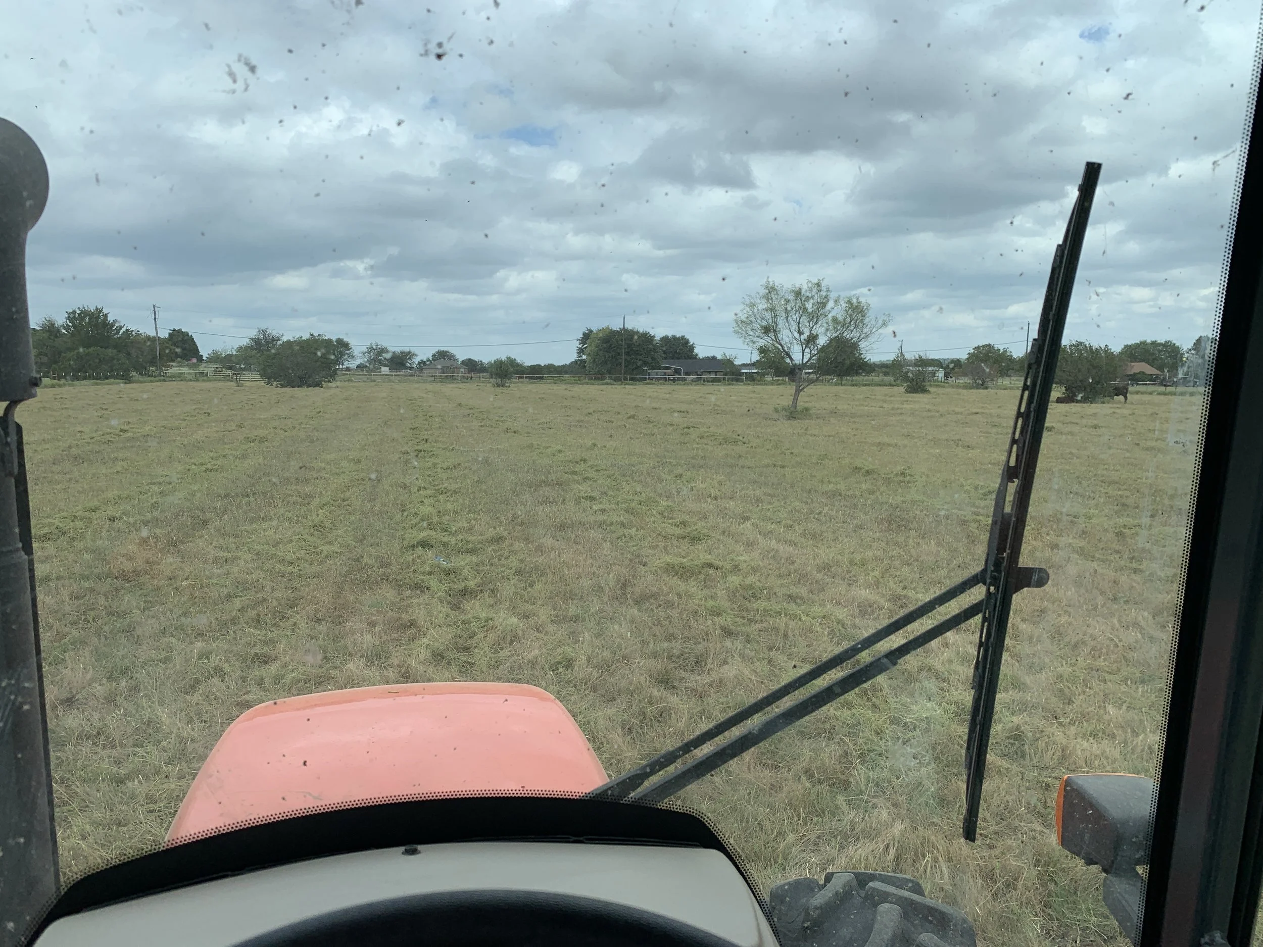 Tractor mowing through brown field