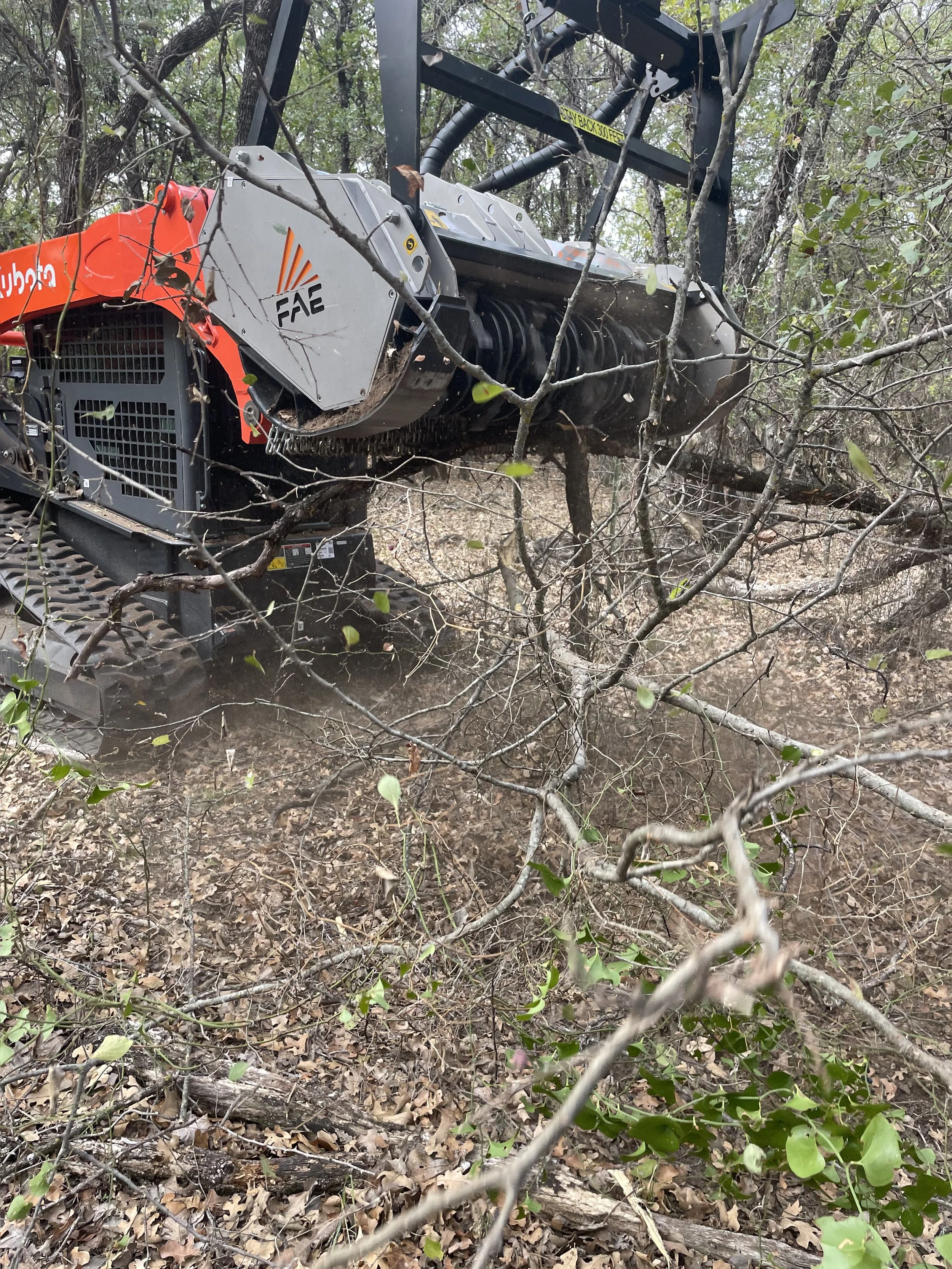 Skid-steer mowing around trees