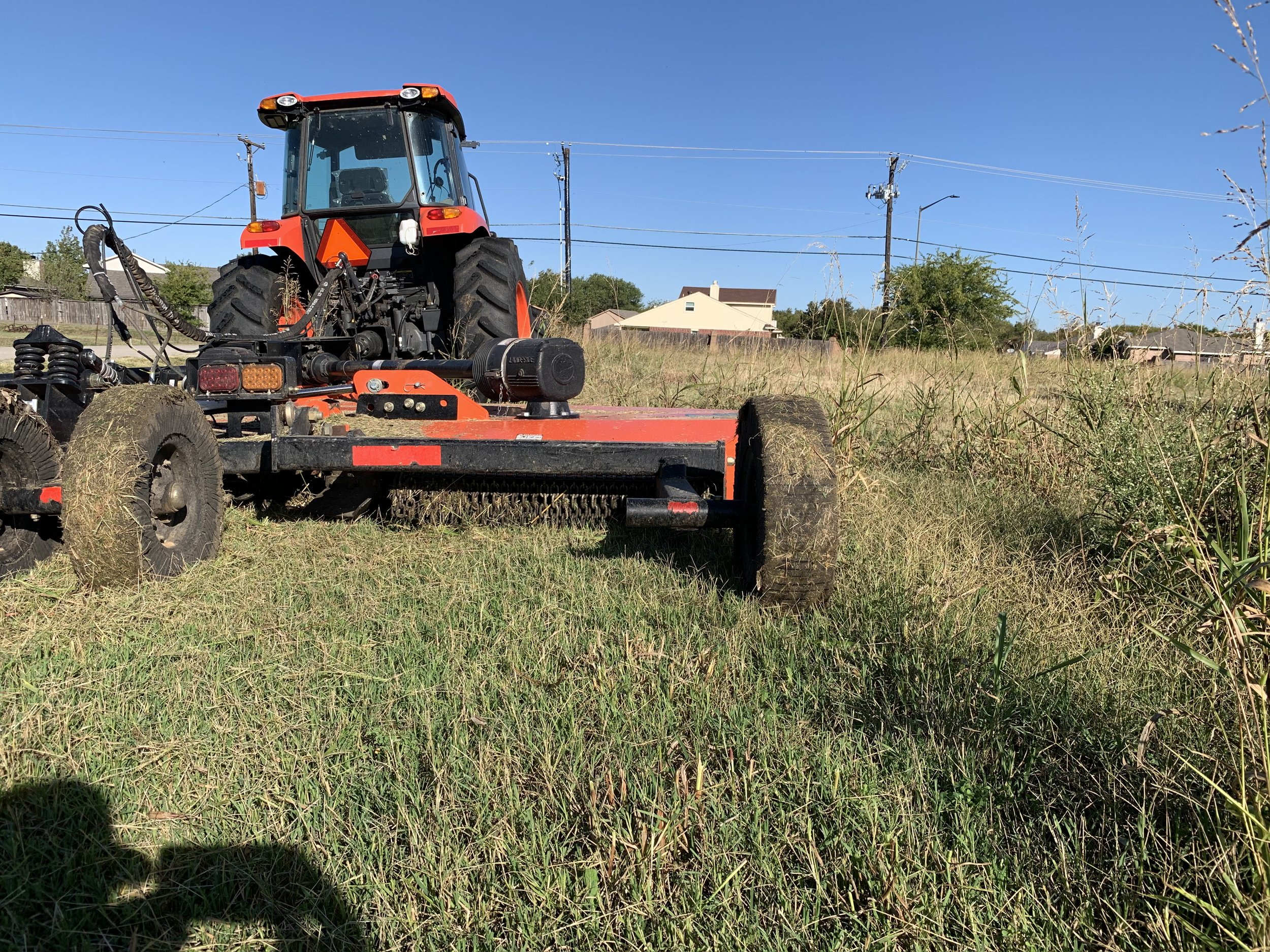 Tractor mowing tall grass field