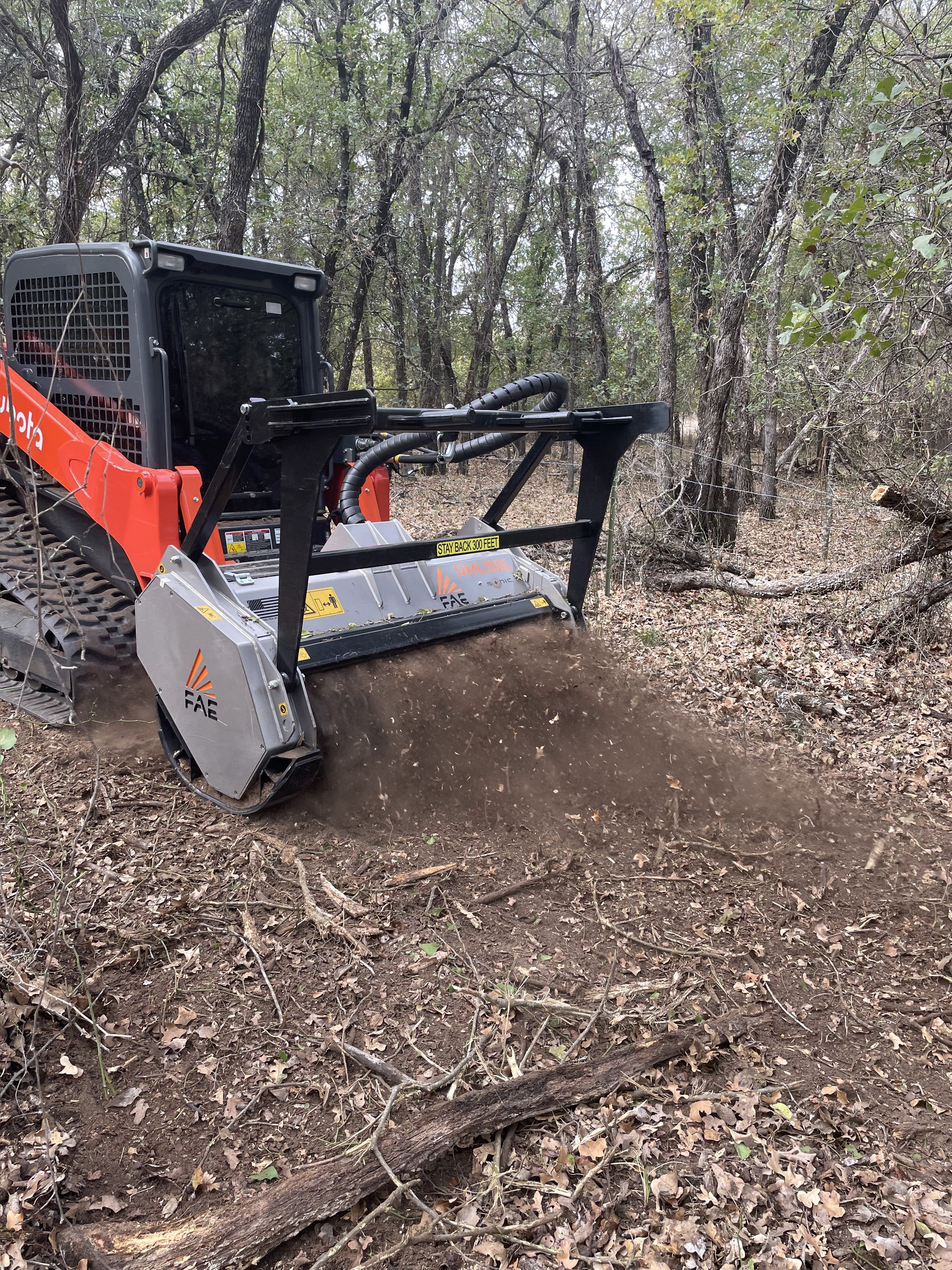 Skid-steer mowing around trees