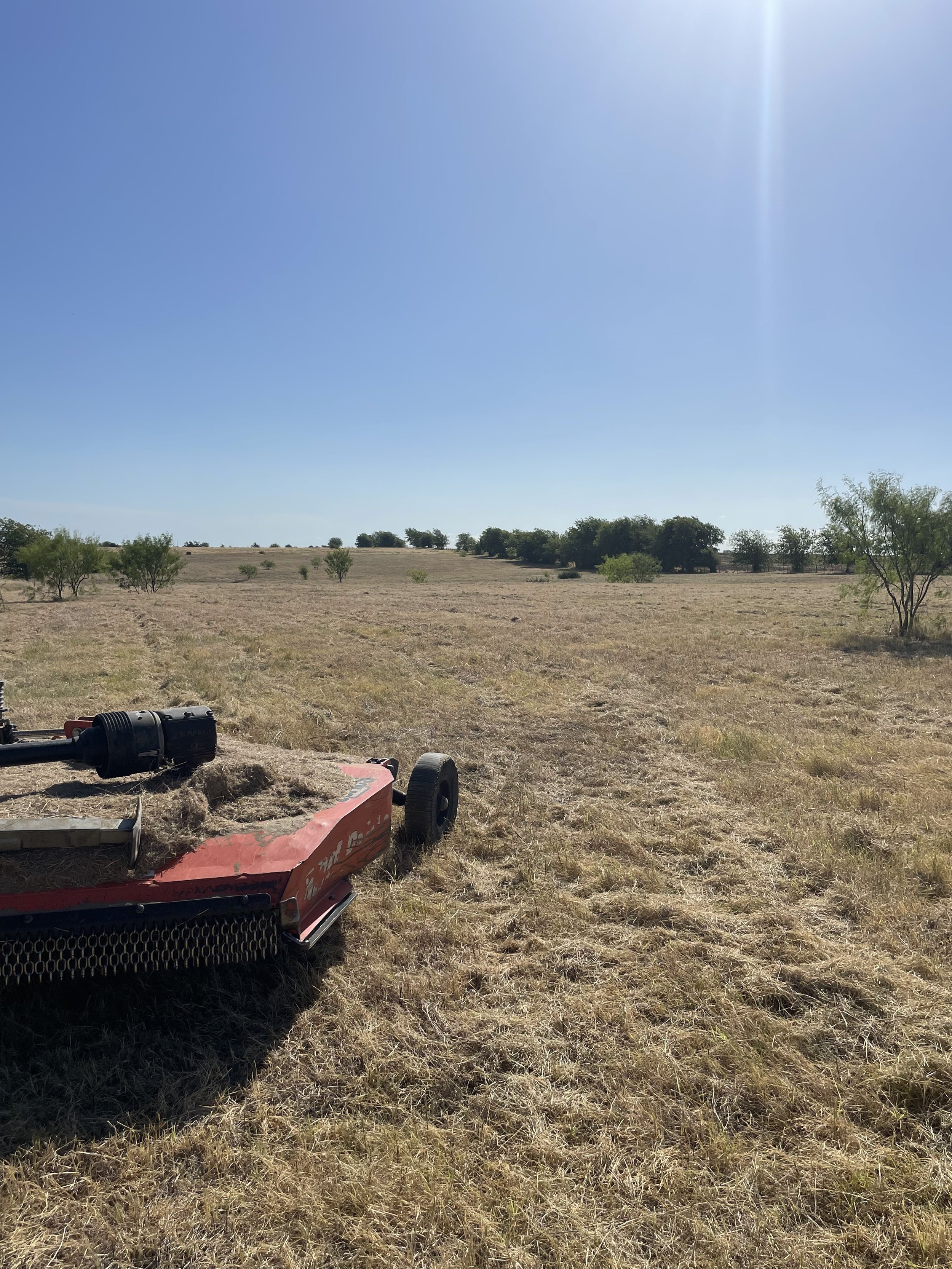 Tractor mowing through a field 