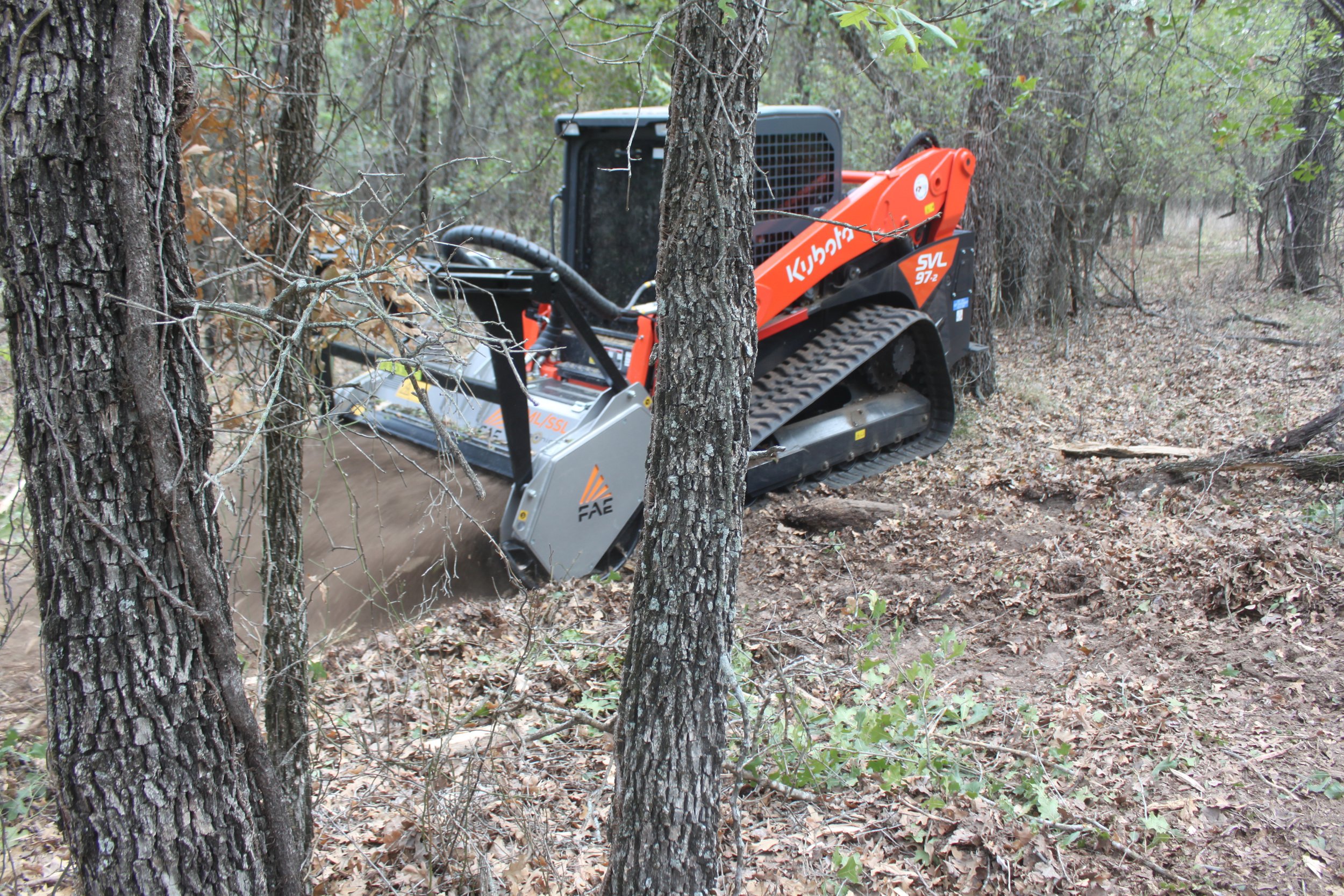 Skid-steer mowing through trees