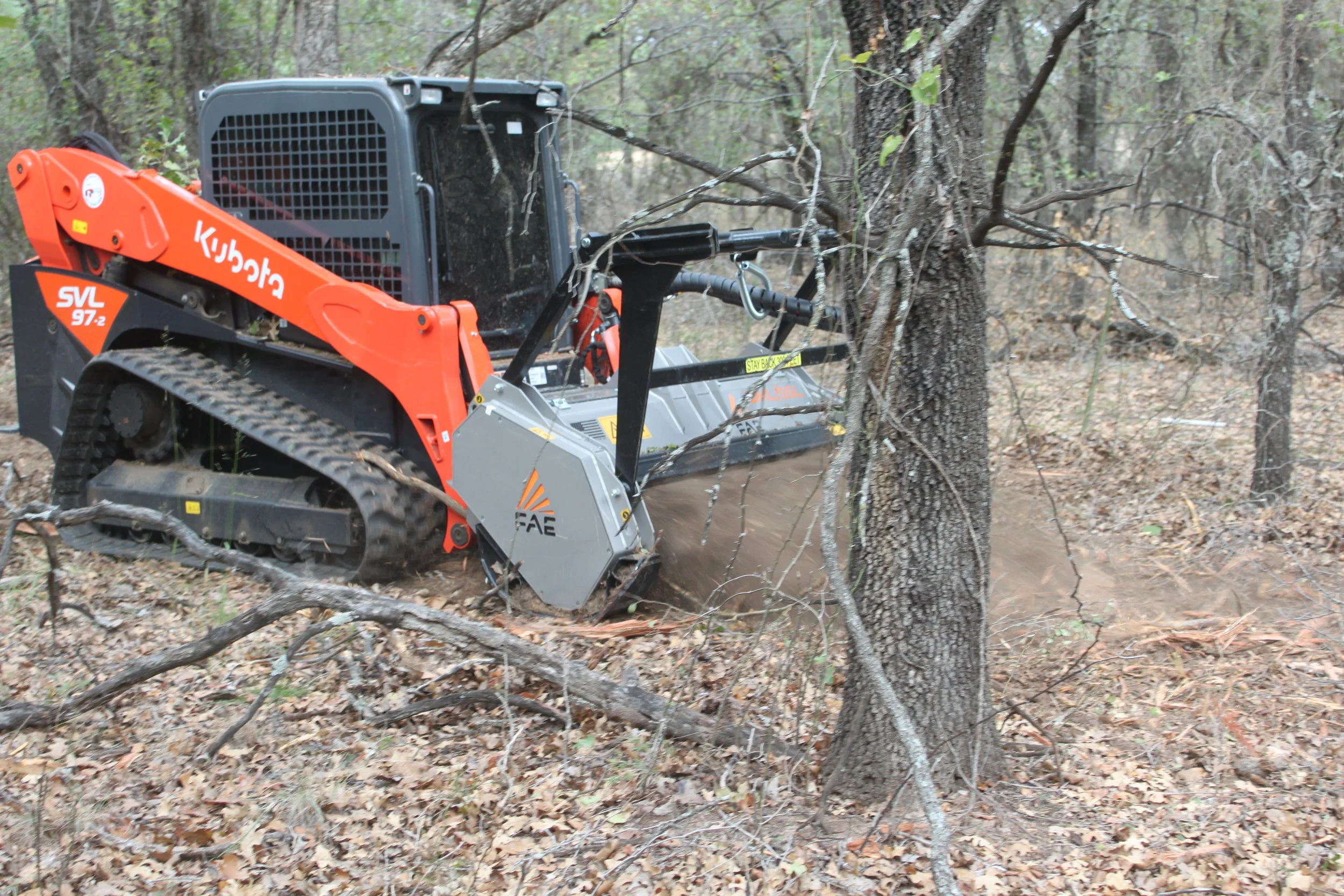 Skid-steer mowing around trees
