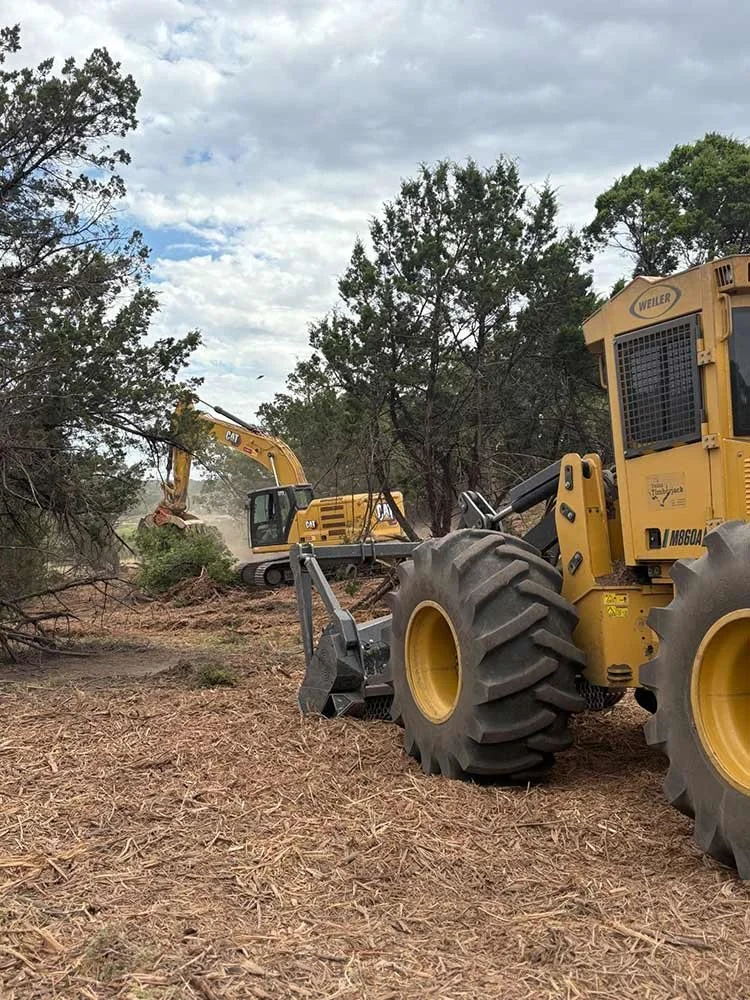 A fleet of heavy machinery clearing trees and brush