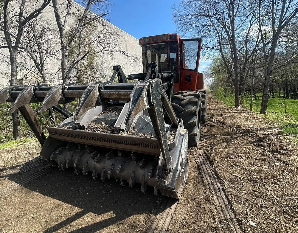Heavy forestry mulching machinery on a dirt path